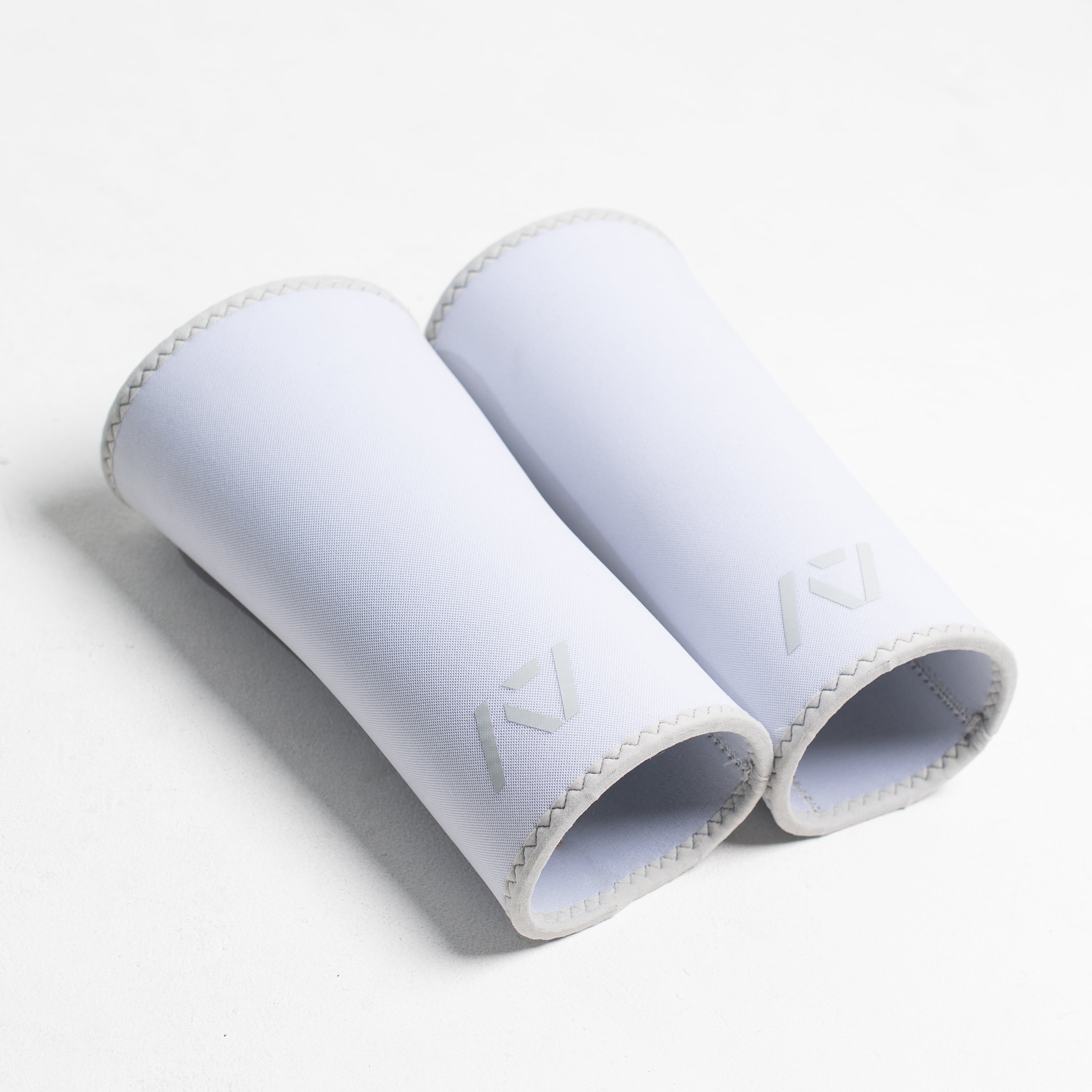 Pair of white hourglass knee sleeves on a white background