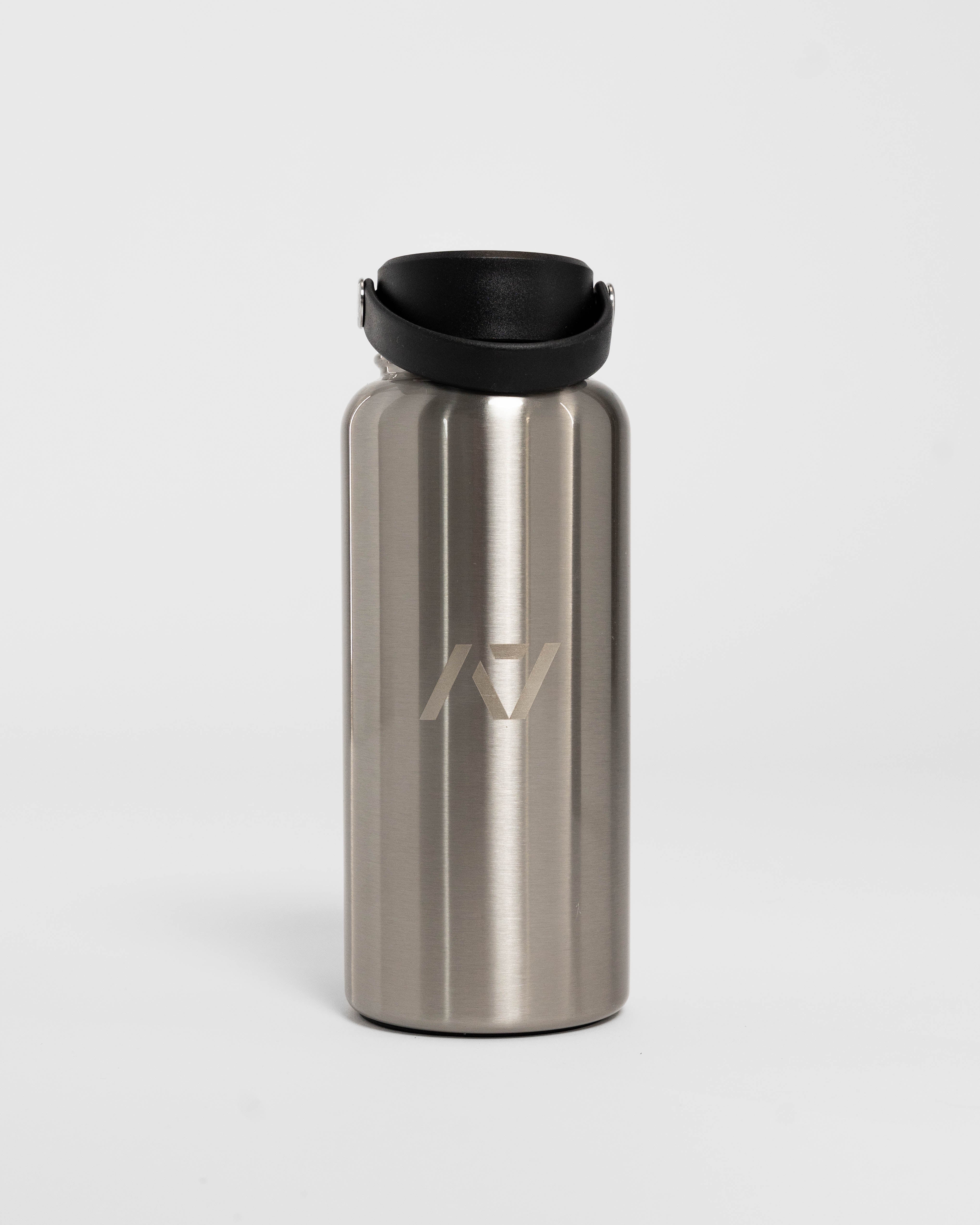 Stainless steel water bottle with black lid on a light gray background