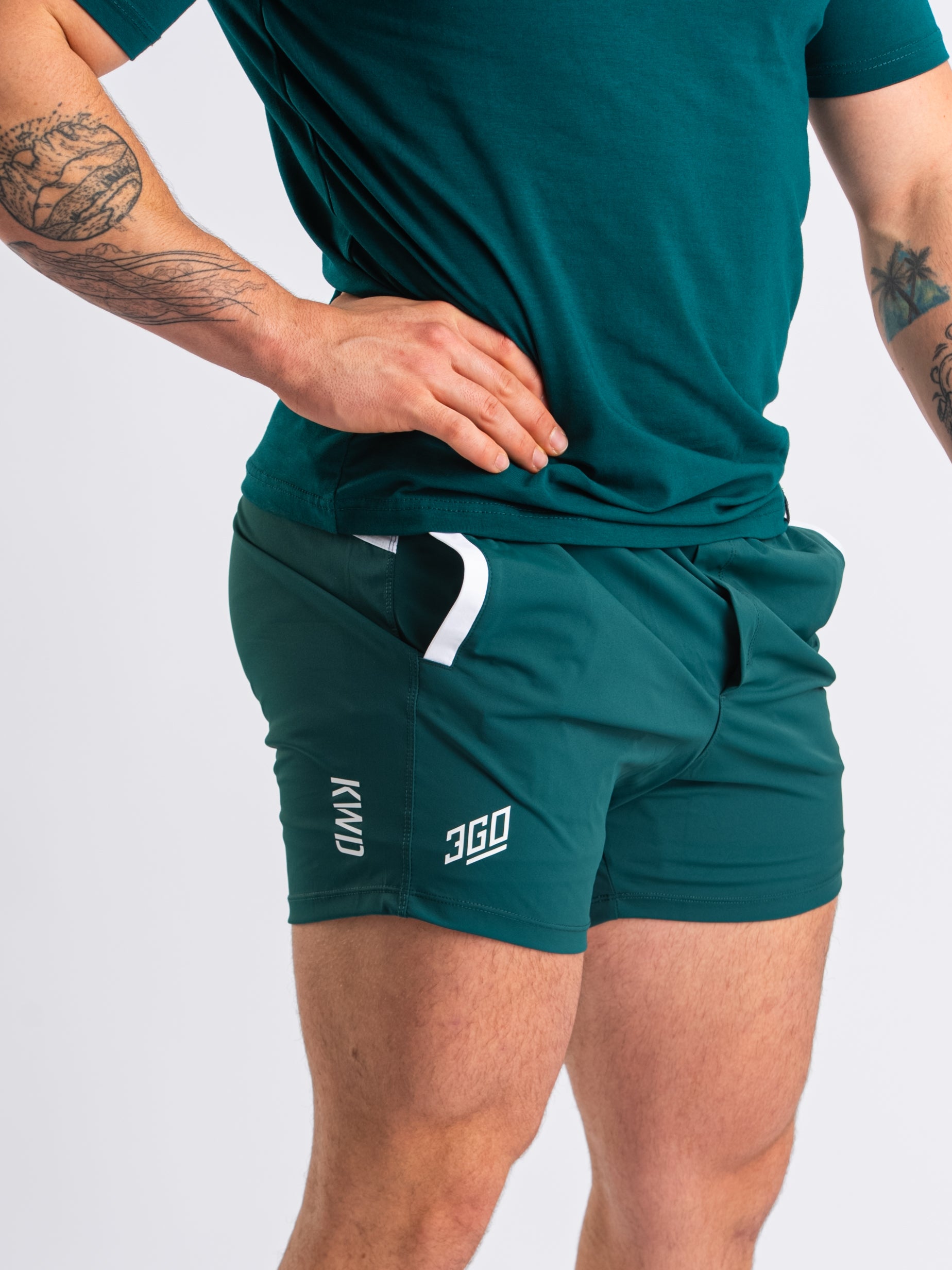 Side profile of Emerald Forás 360Go 1Z KWD Shorts featuring wide drawstring waistband and stretch fabric fit.