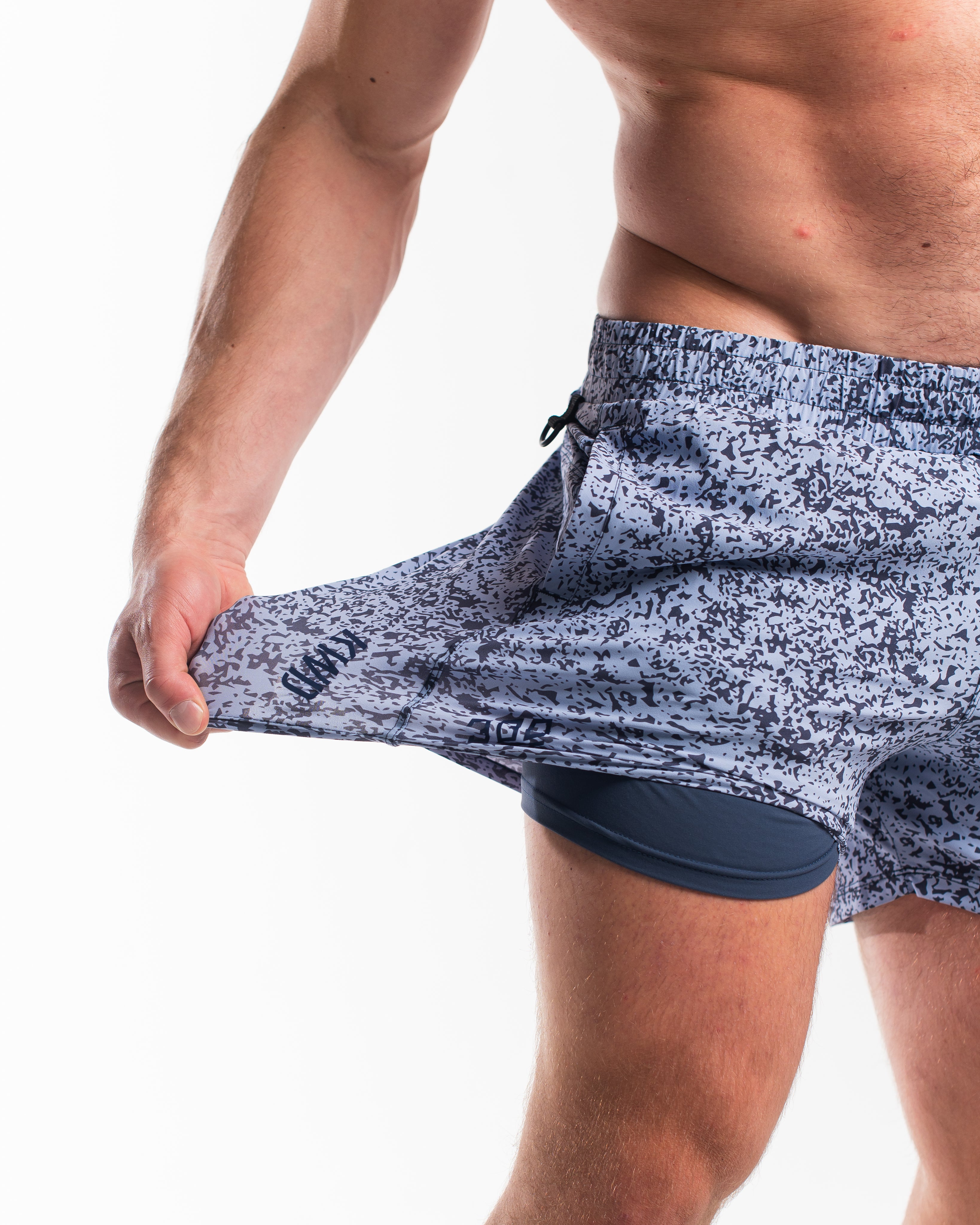 Demonstration of the 360-degree stretch fabric on A7 360Go 1Z KWD Shorts in Foggy Navy, offering full range of motion for training and lifting