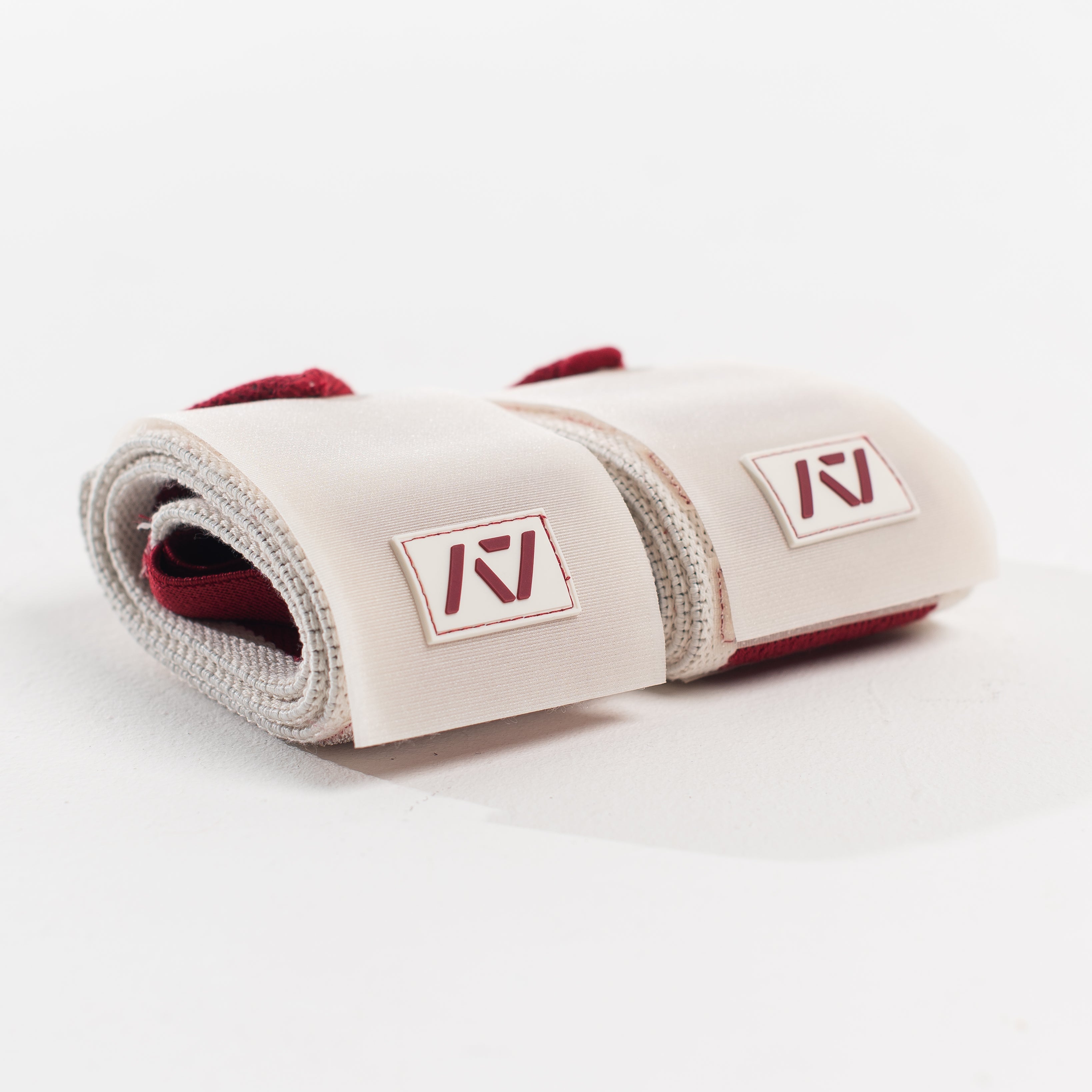 Close up of A7 logo patch on both wrist wraps in ivory with red accents