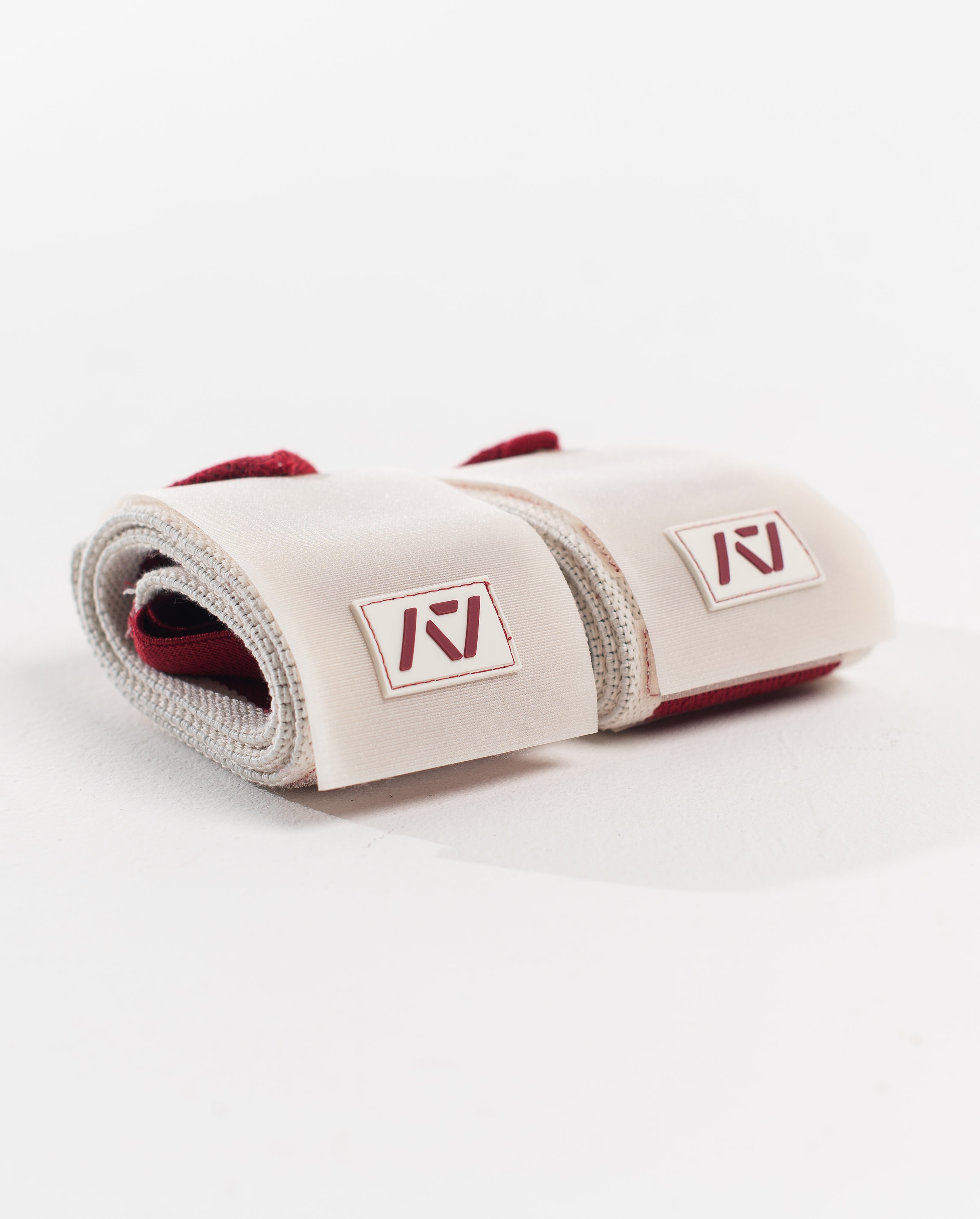 Close up of A7 logo patch on both wrist wraps in ivory with red accents