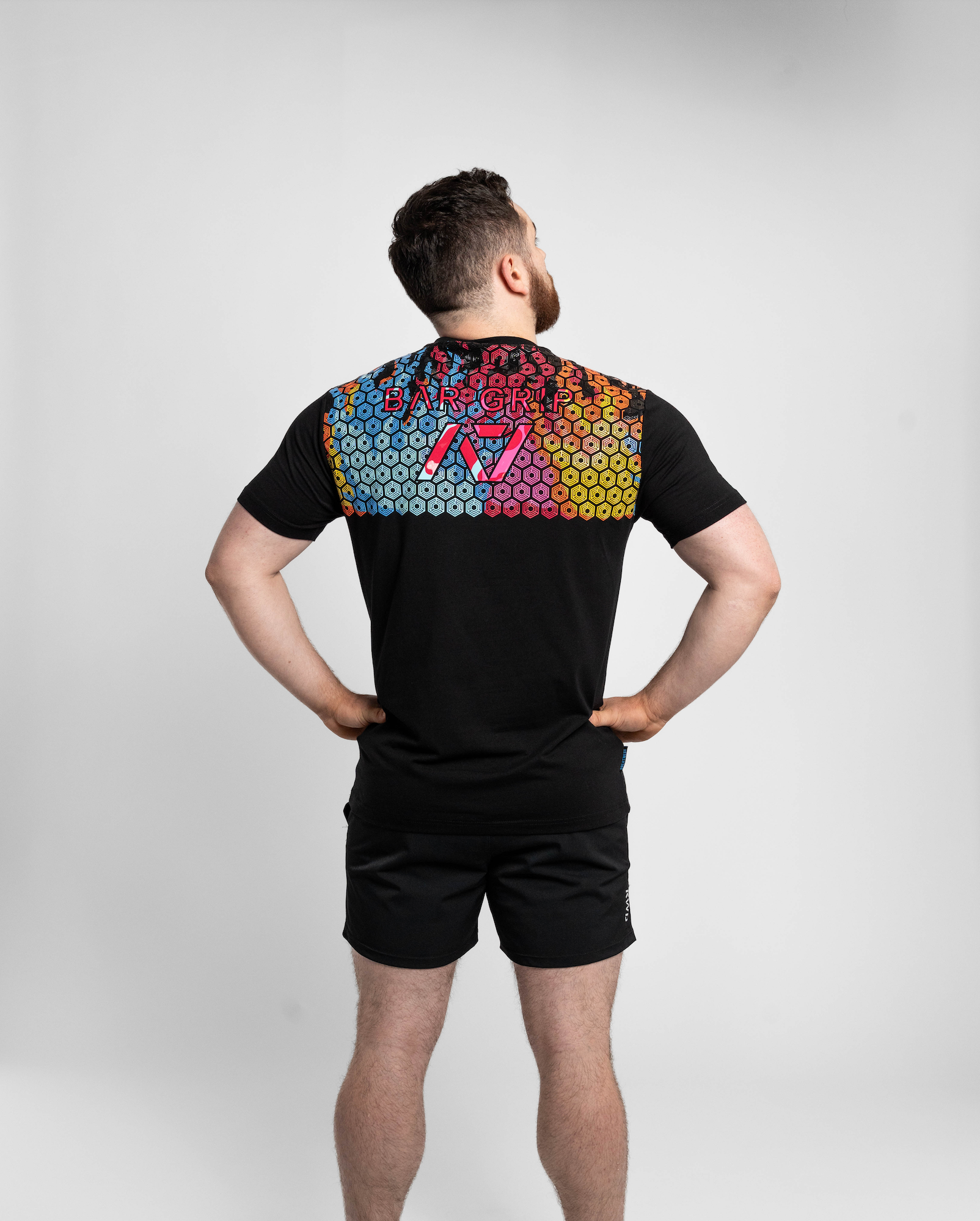 Person wearing a black t-shirt with bar grip on the back against a white background