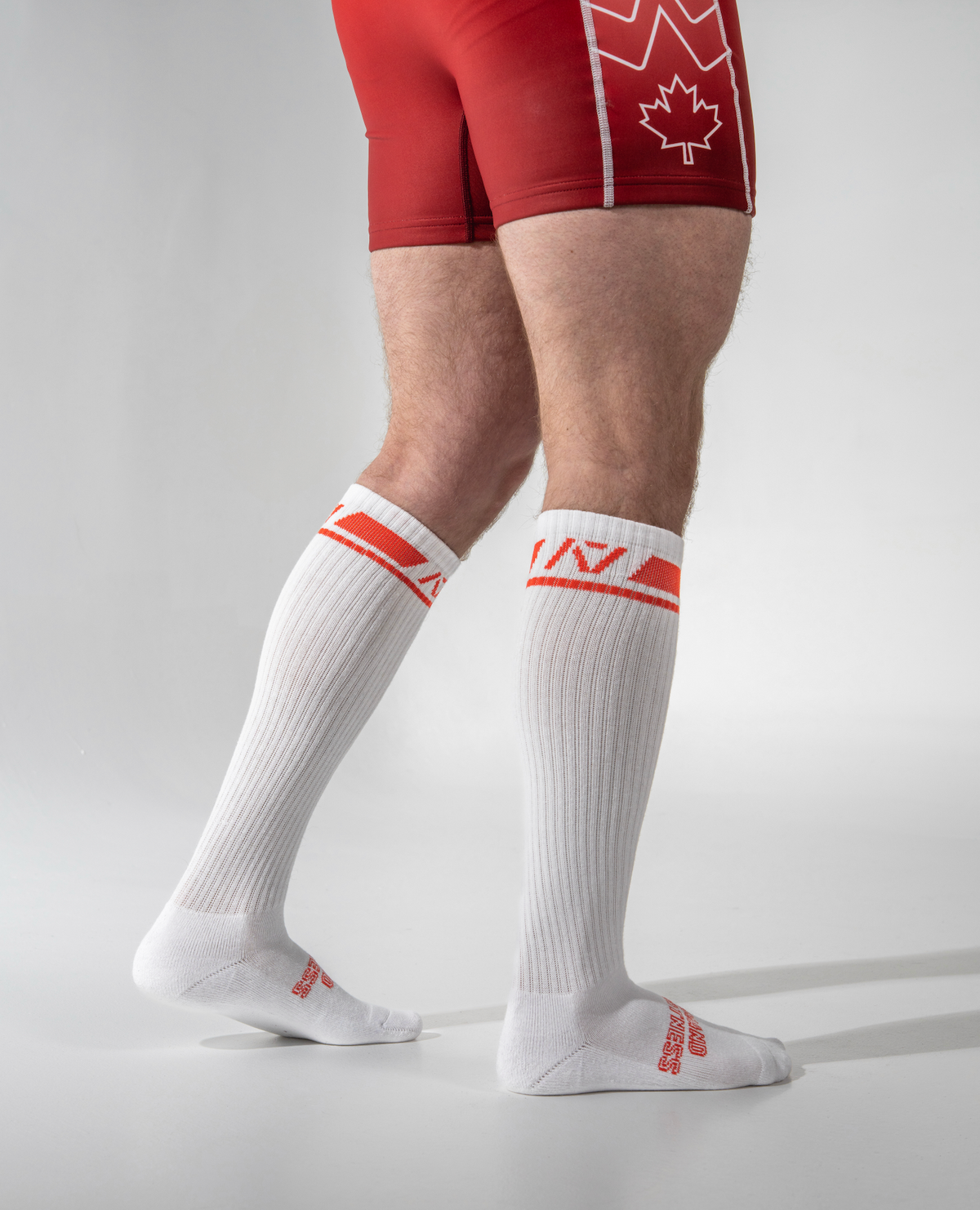 White socks with red accents worn by a person on a gray background