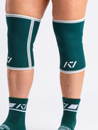 Side view of lifter executing stood with A7 Hourglass Knee Sleeves – Emerald Forás, highlighting snug fit and support during powerlifting.