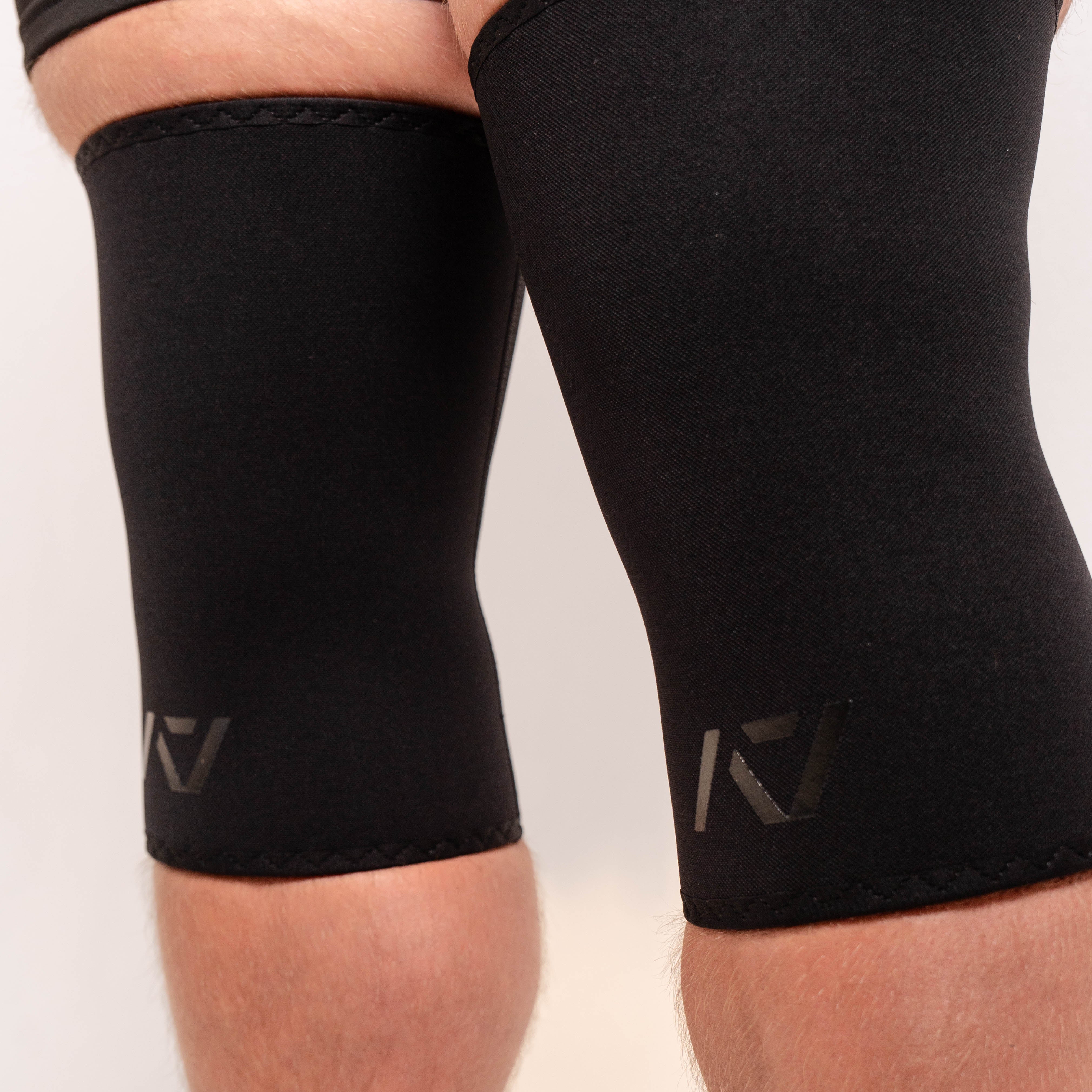 Side view of A7 Hourglass Knee Sleeves – Stealth on lifter's knees, highlighting the hourglass design.