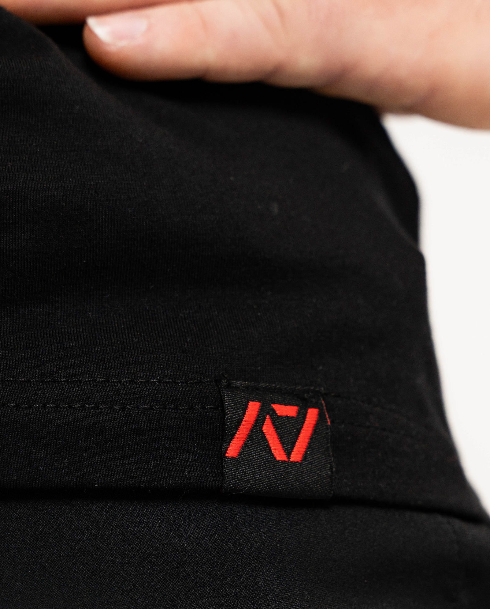 Black fabric with a red logo tag on a blurred background