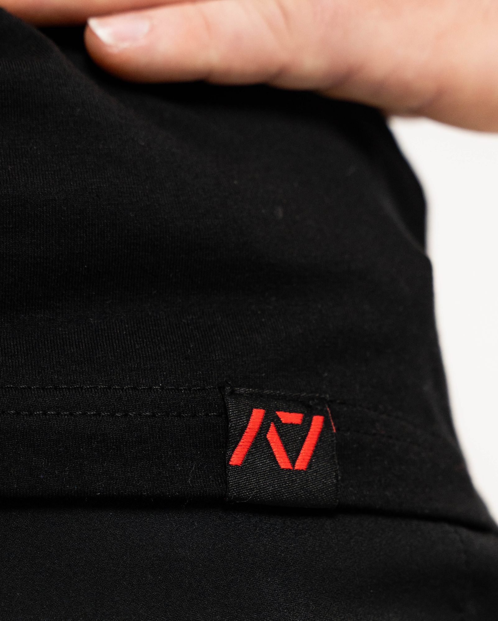 Black fabric with a red logo tag on a blurred background