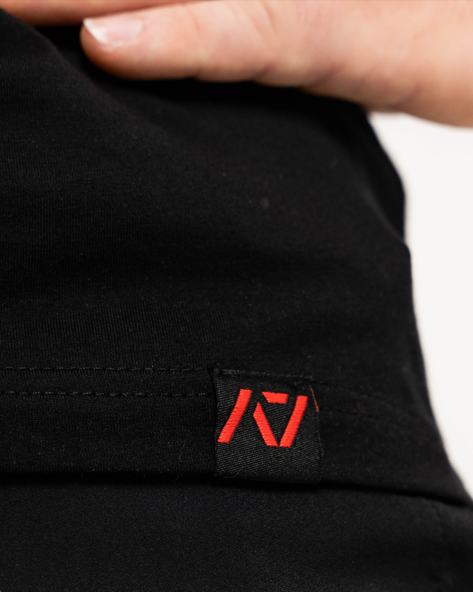 Black fabric with a red logo tag on a blurred background