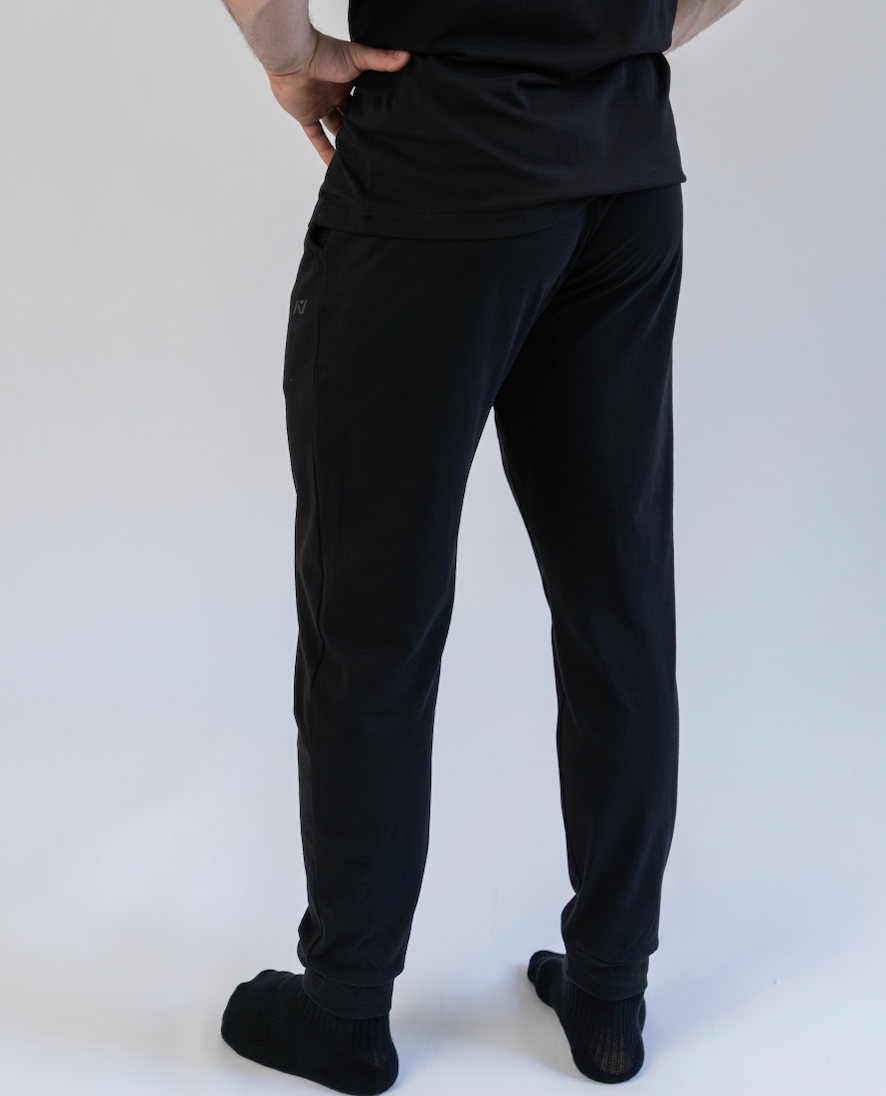 Person wearing black pants and a black shirt on a white background