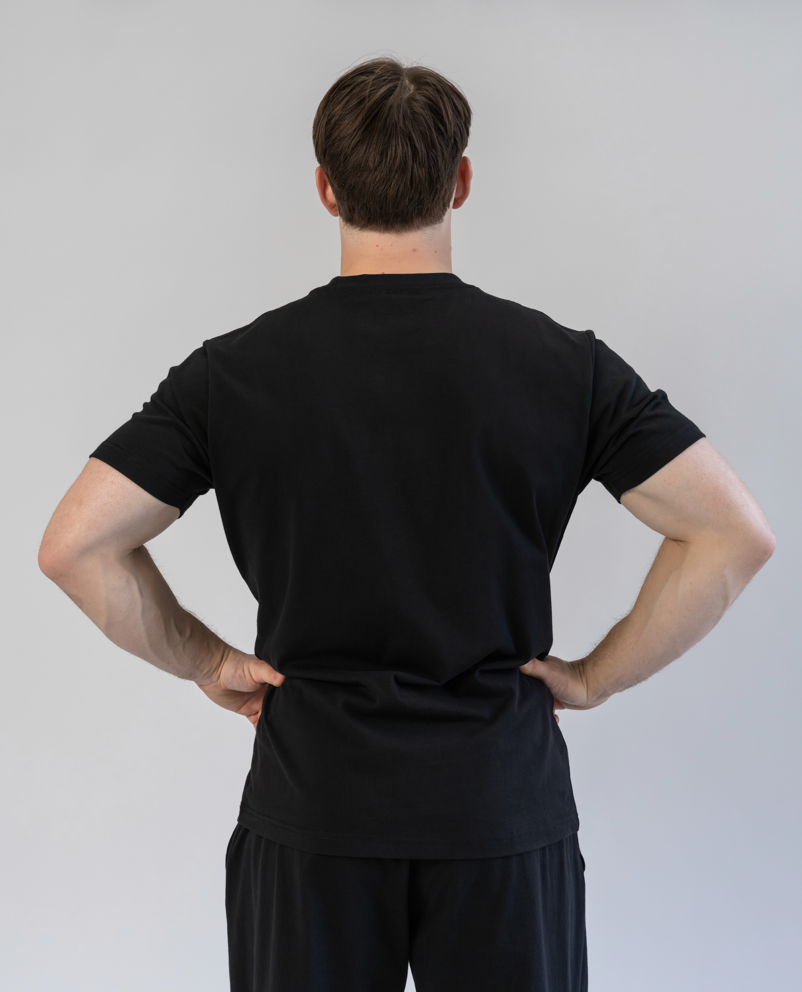 Person wearing a black outfit against a plain background