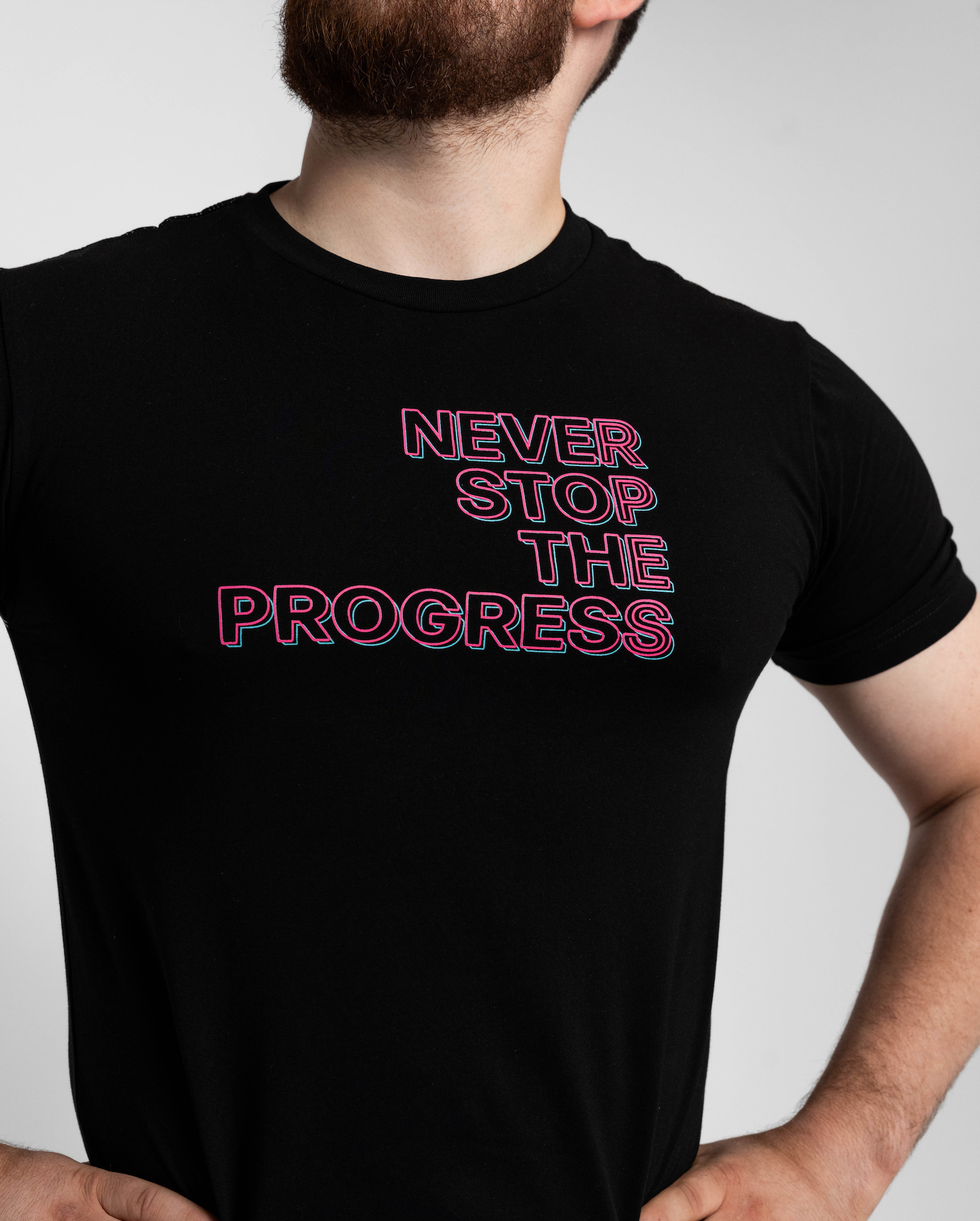 Person wearing a black t-shirt with 'Never Stop The Progress' text.