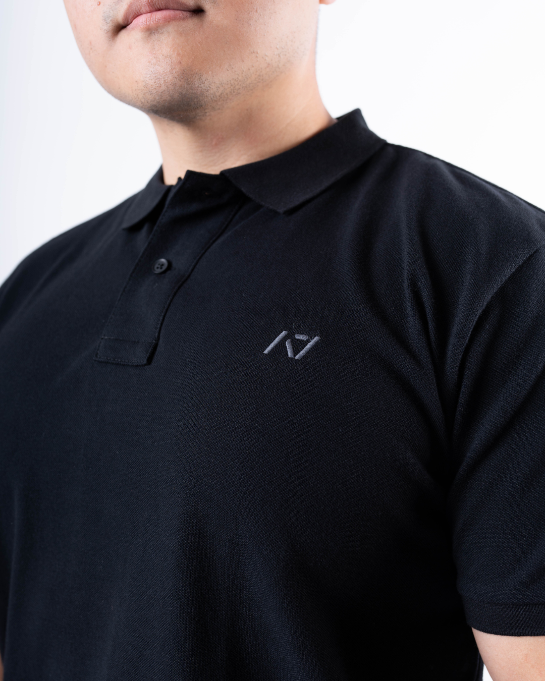 Close-up of the rib-knit polo collar on the A7 Cotton Polo in Black.