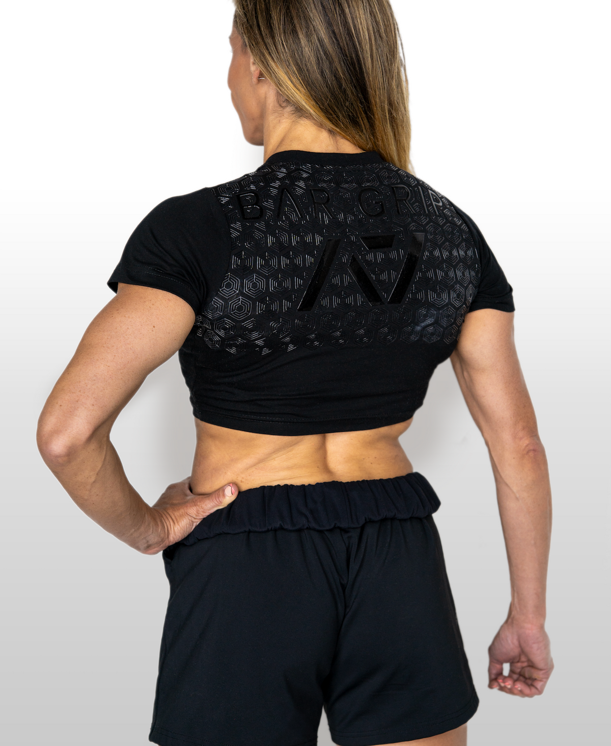 Person wearing a black athletic outfit with A7 BAR GRIP on a white background