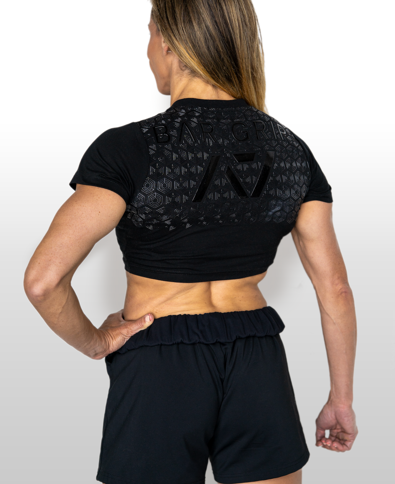 Person wearing a black athletic outfit with A7 BAR GRIP on a white background