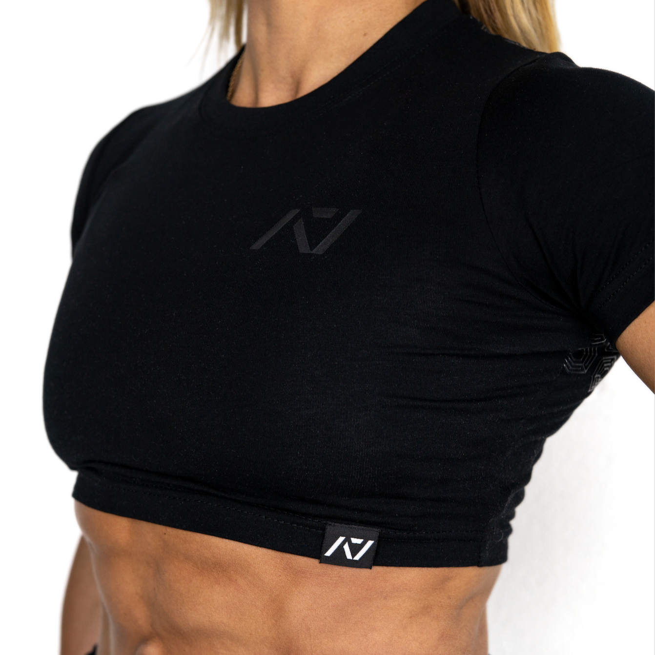 Person wearing a black athletic outfit with a visible brand logo on a white background