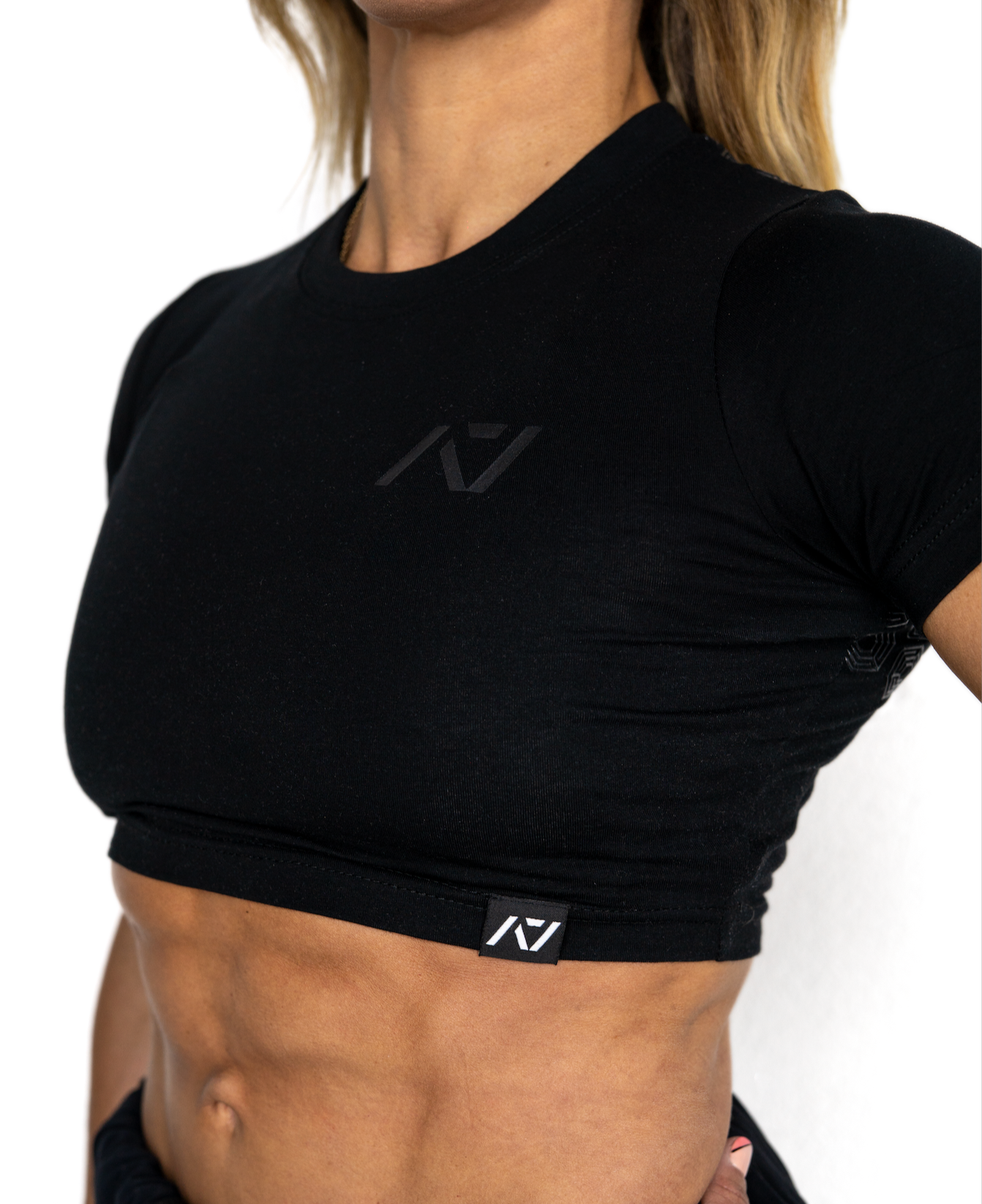 Person wearing a black athletic outfit with a visible brand logo on a white background