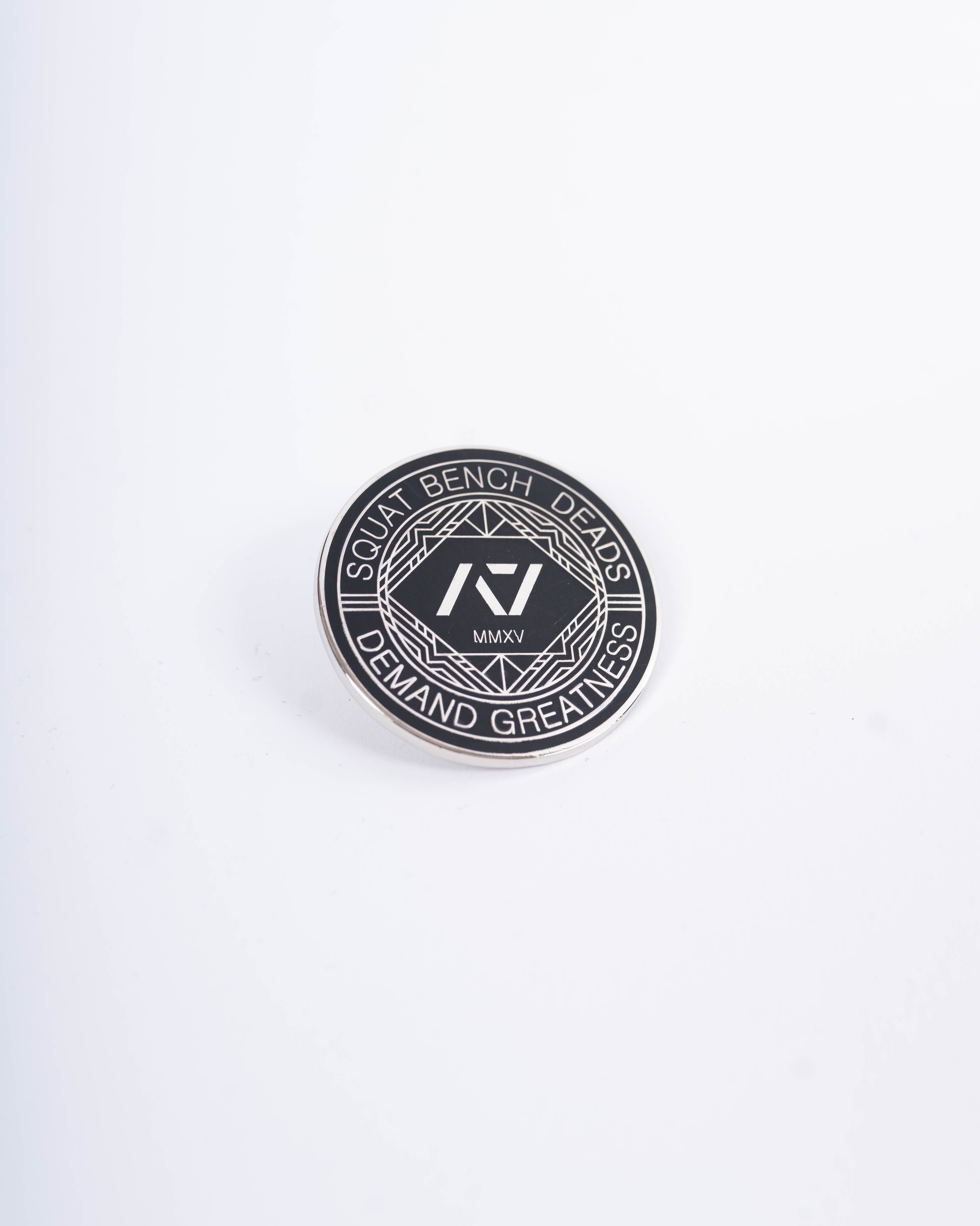 Front view of A7 Revive Pin featuring raised enamel design in black with symbolic crest detailing.