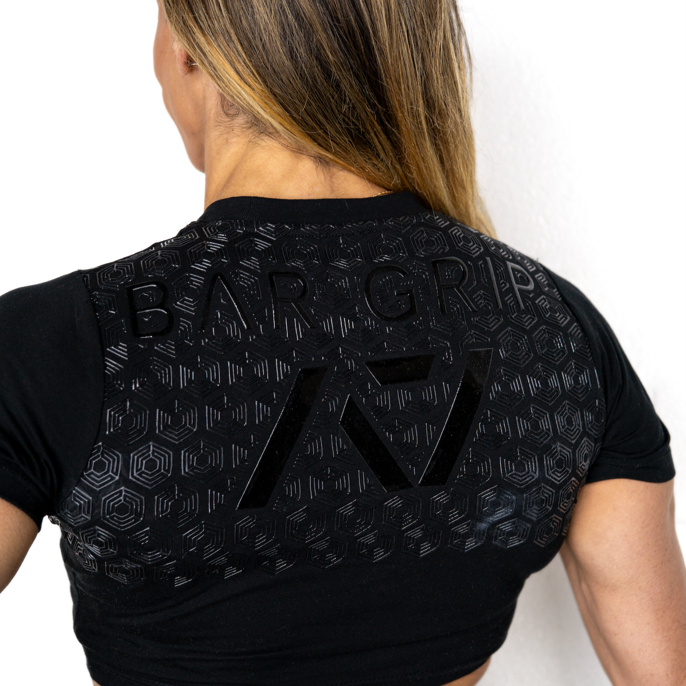 Person wearing a black athletic outfit with A7 bar grip on a white background