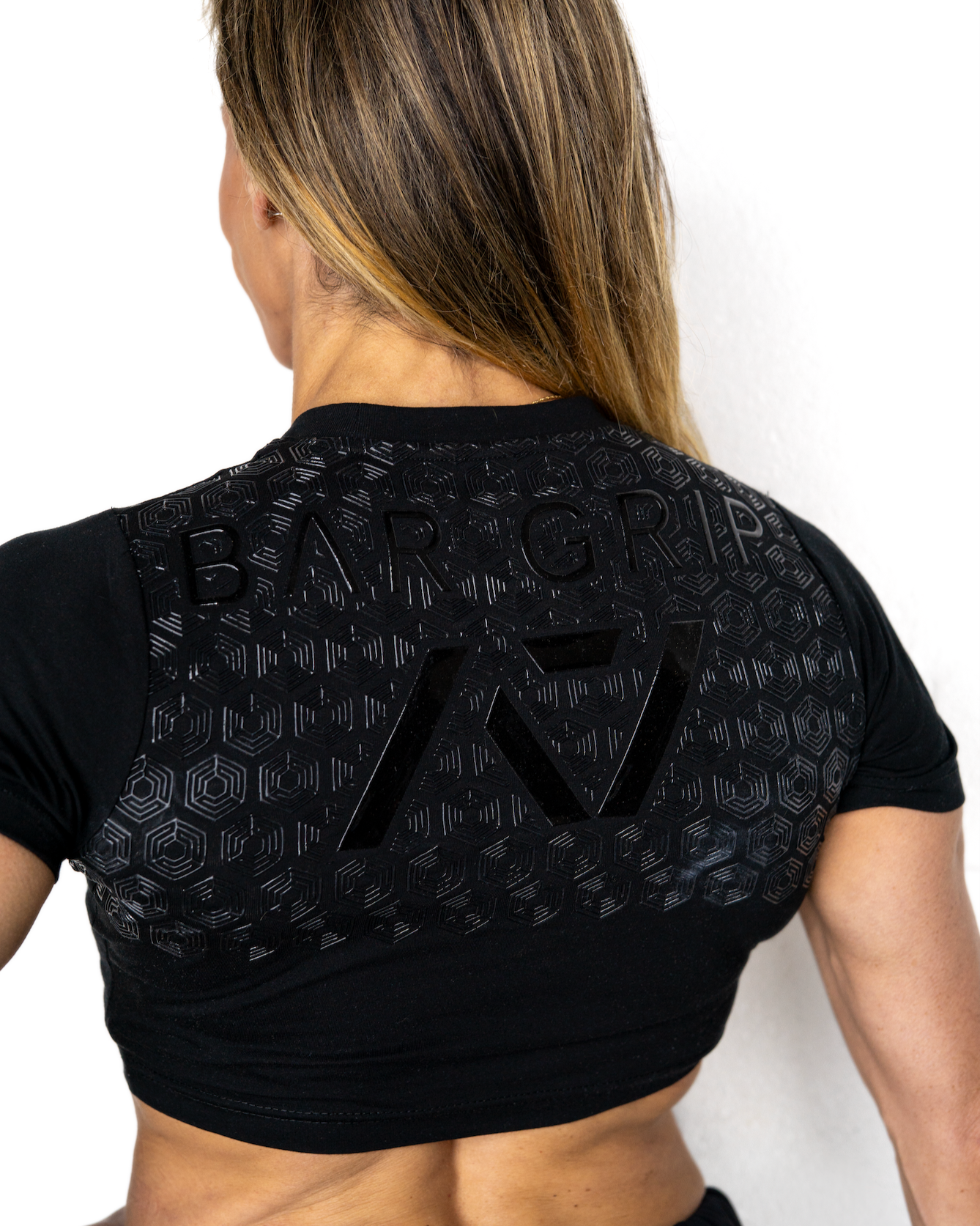 Person wearing a black athletic outfit with A7 bar grip on a white background