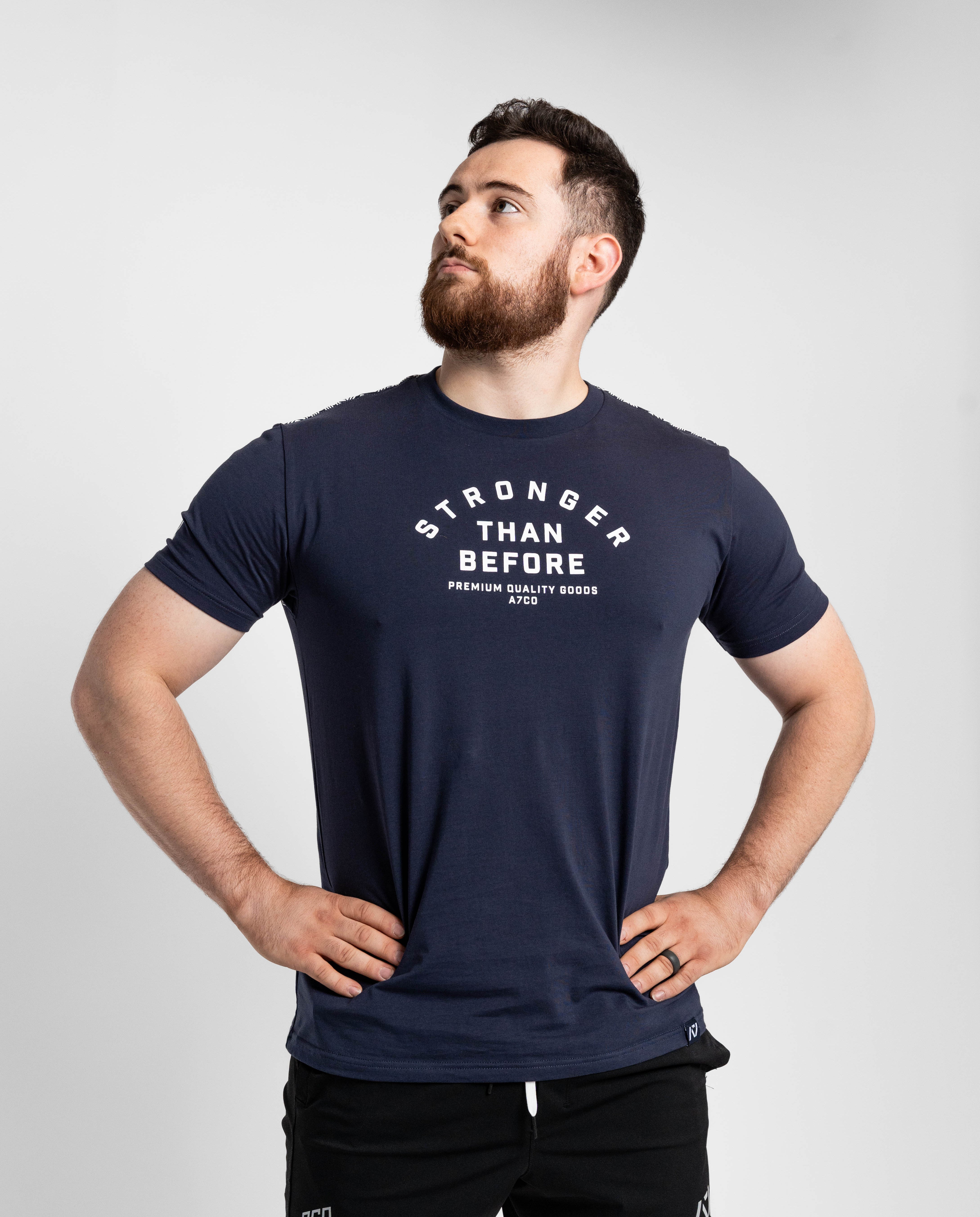 Man wearing a navy blue t-shirt with 'Stronger Than Before' text on a light gray background