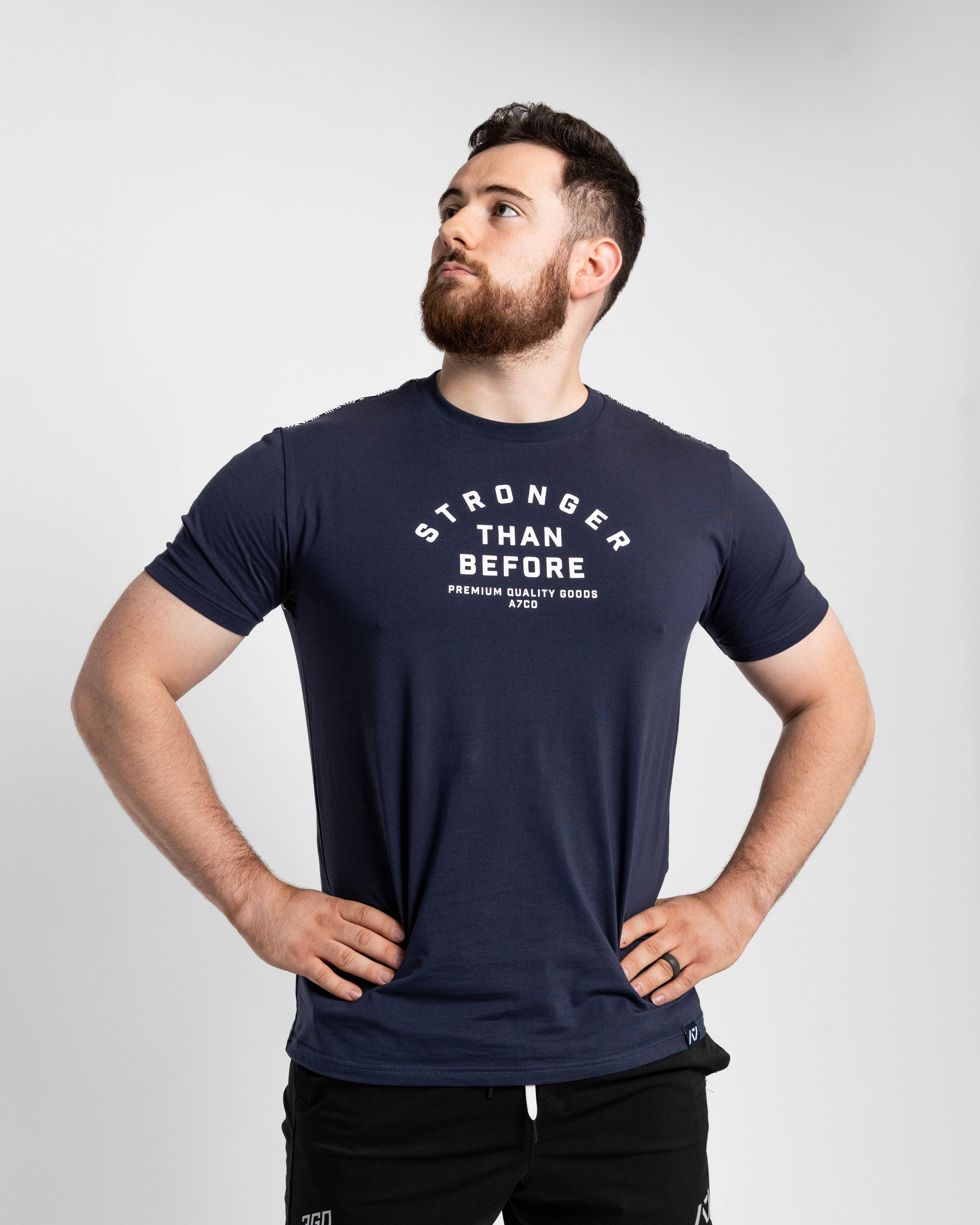 Man wearing a navy blue t-shirt with 'Stronger Than Before' text on a light gray background