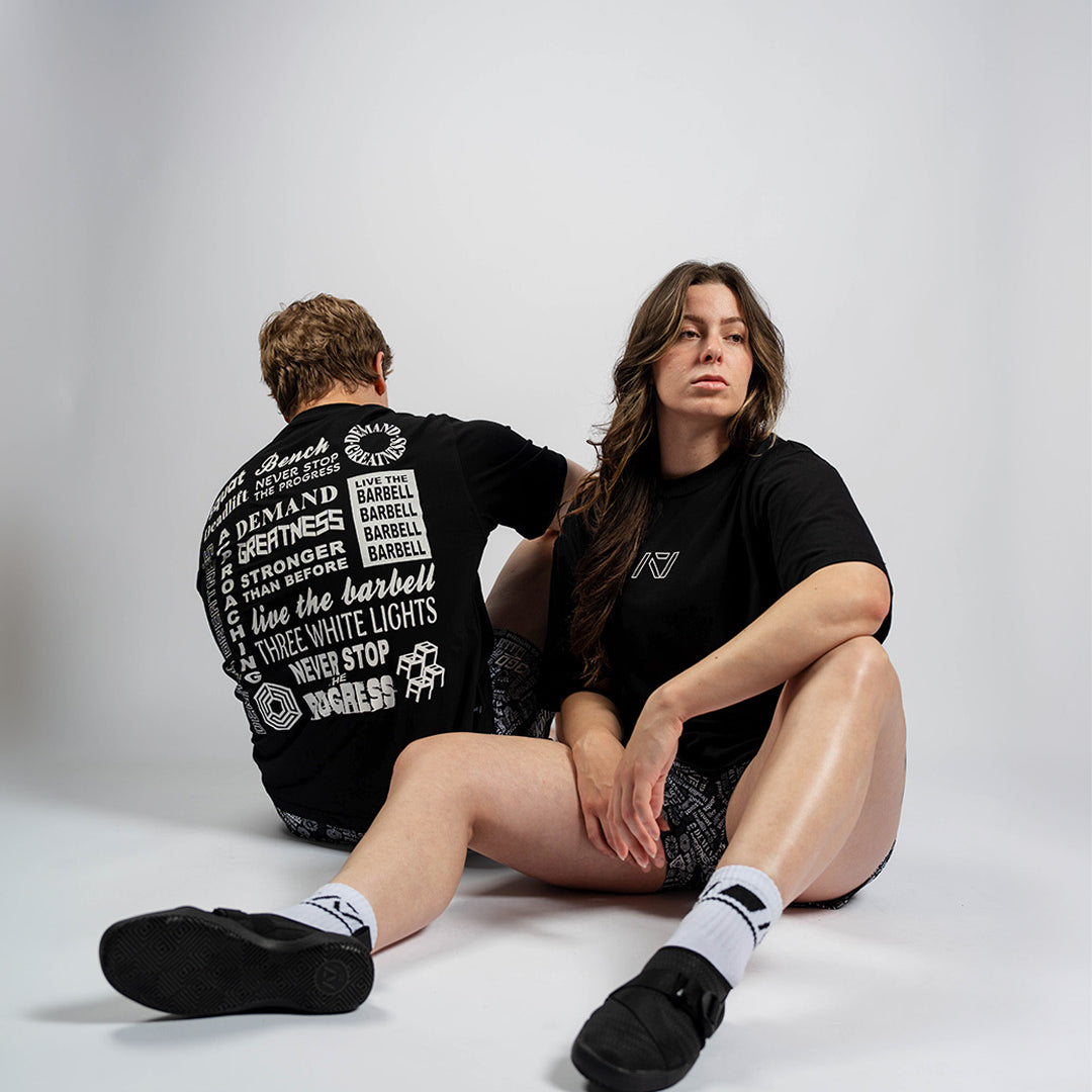 Male and female athletes wearing the A7 Affirmation Over-Fit Unisex Shirt – Domino, showcasing relaxed oversized fit on both body types.