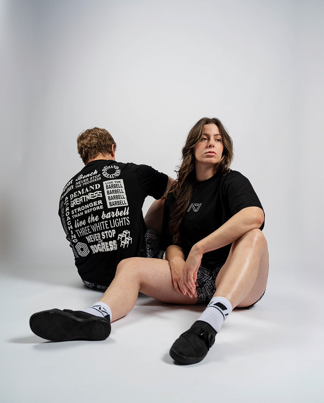 Male and female athletes wearing the A7 Affirmation Over-Fit Unisex Shirt – Domino, showcasing relaxed oversized fit on both body types.