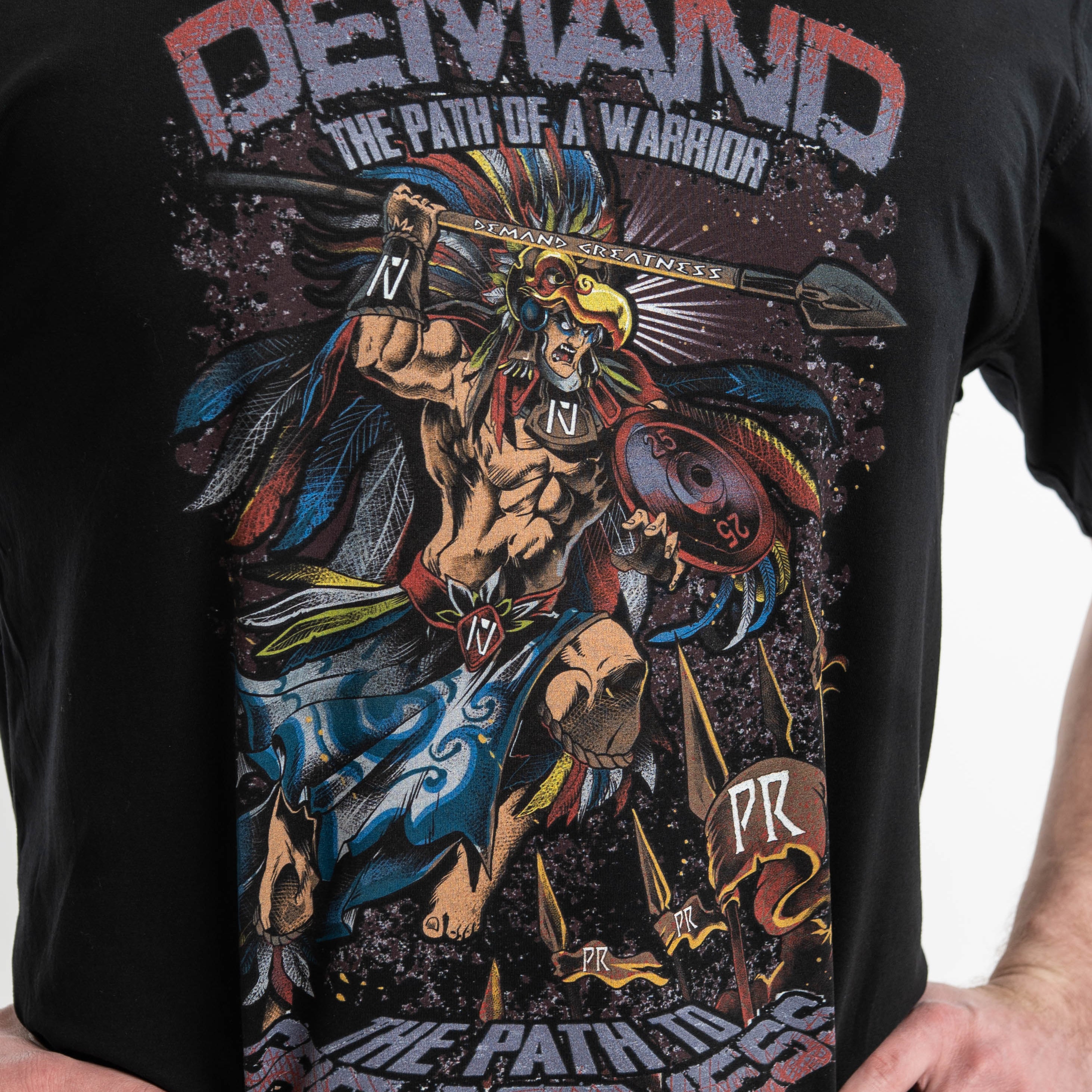 Close-up of the Aztec warrior design on the shirt, focusing on the eagle headdress and etched spear.