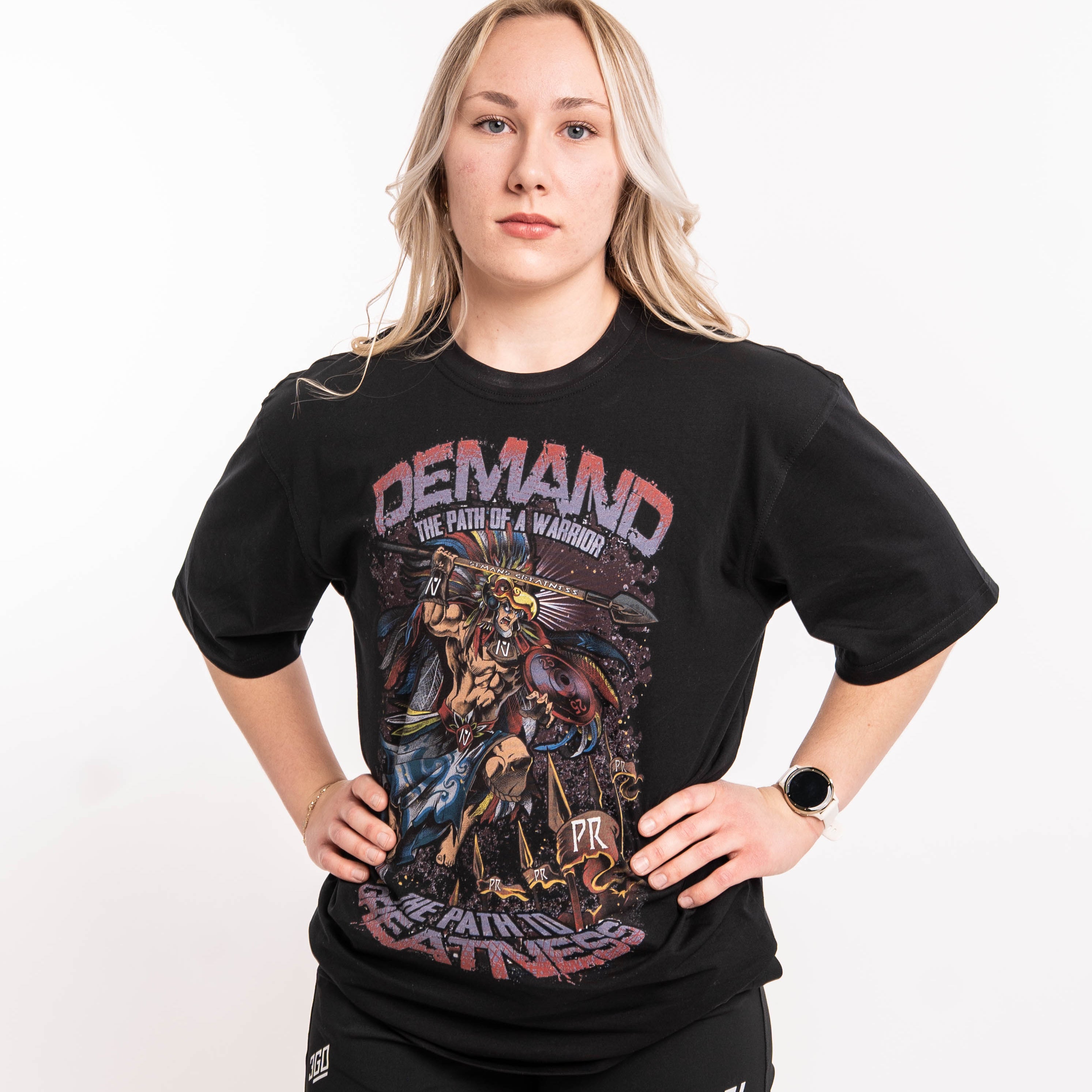 Front view of Aztec Warrior Over-Fit Unisex Shirt showcasing the detailed Aztec warrior design with eagle headdress and "Demand Greatness" spear.