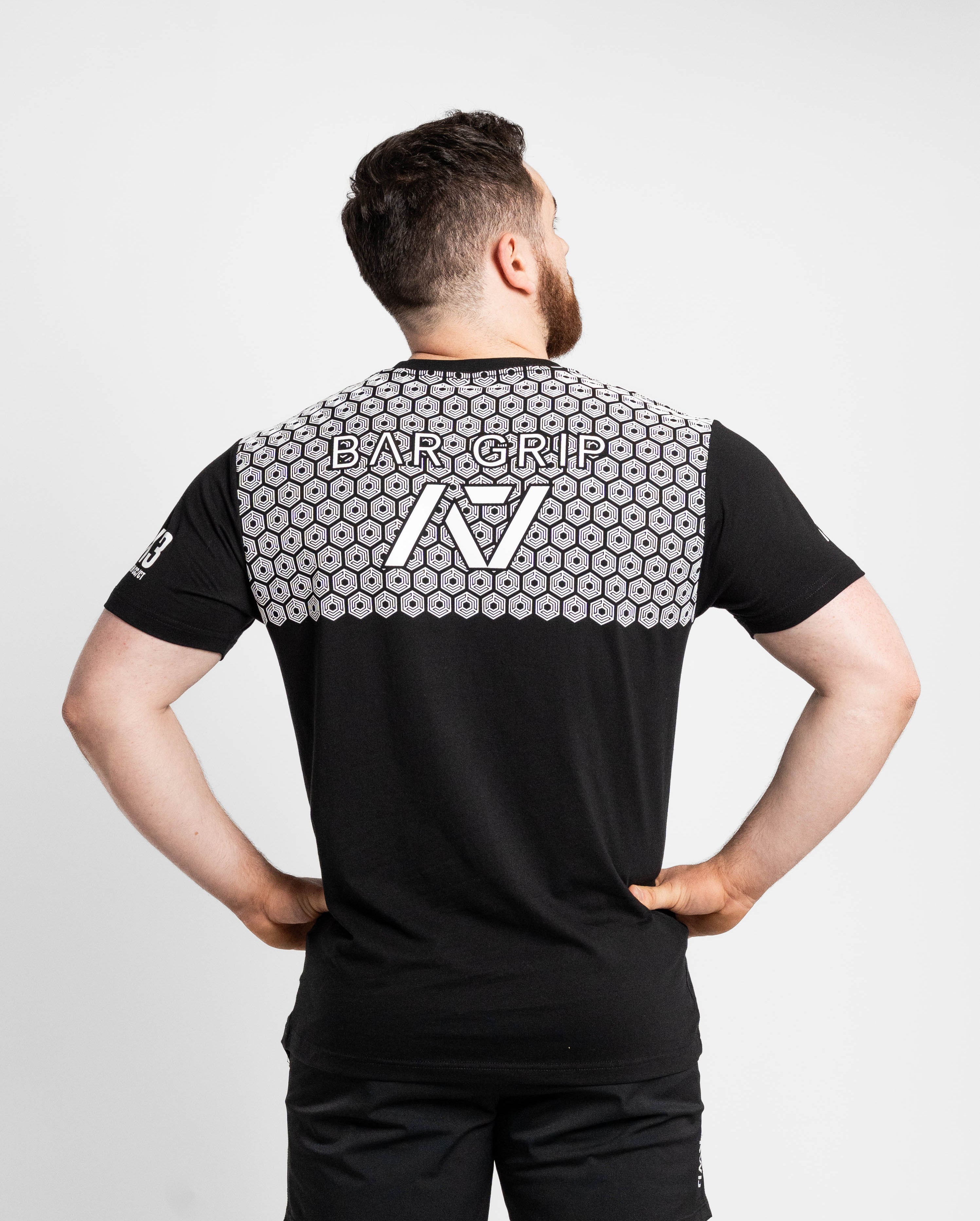 Man wearing a black t-shirt with bar grip and logo on the back against a white background