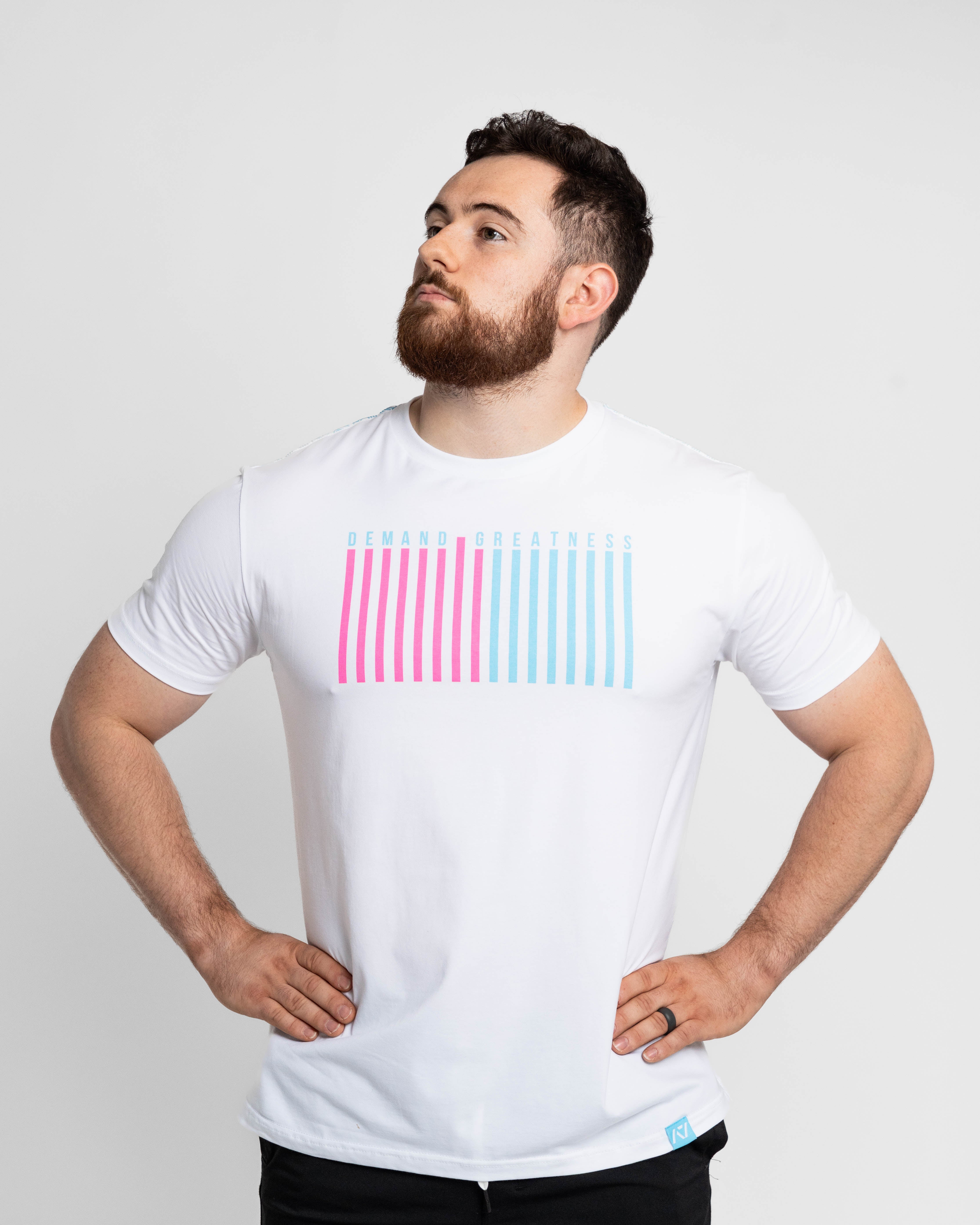 Man wearing a white t-shirt with pink and blue striped design on a light gray background