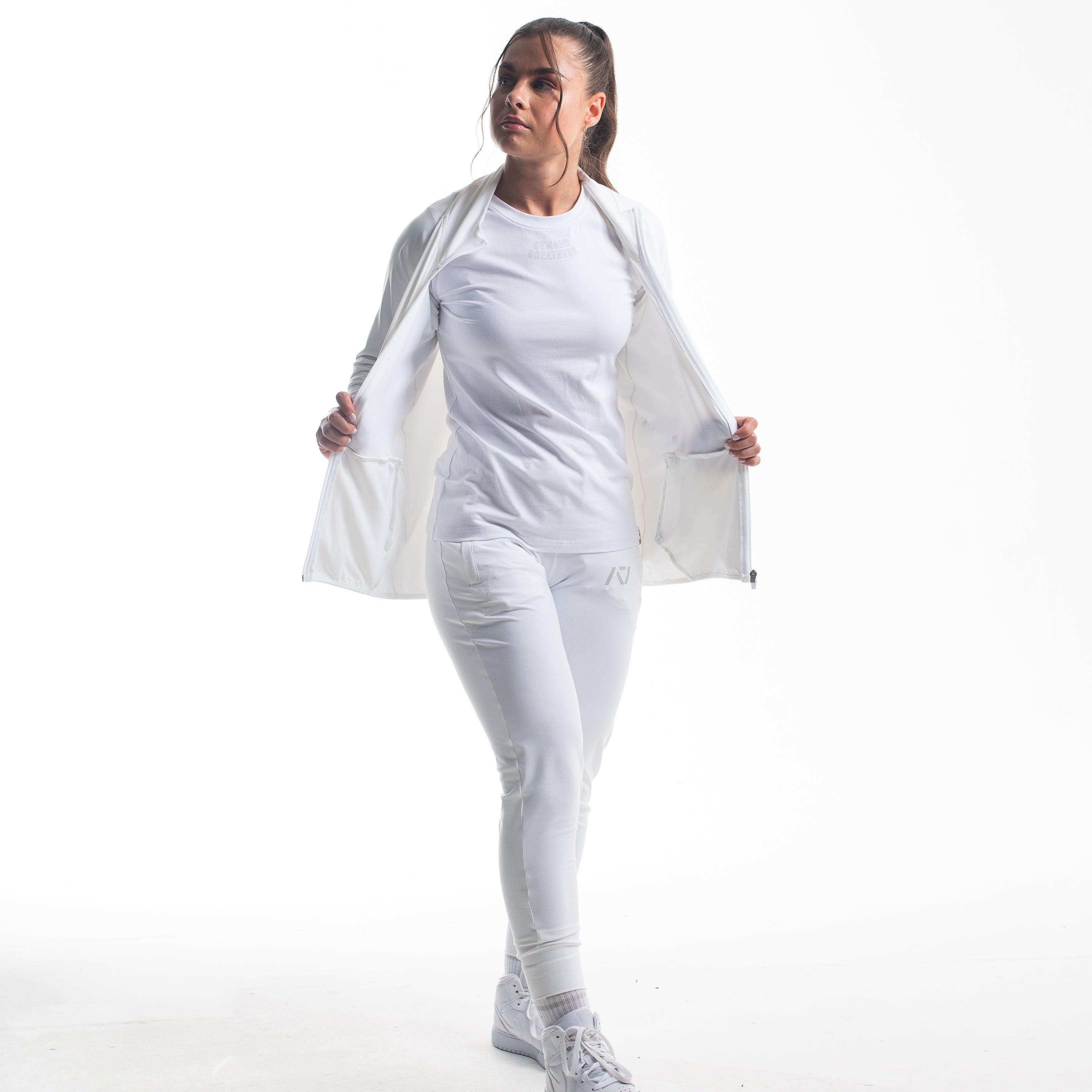 Full body view of athlete wearing the Defy Jacket – Polar, highlighting the tapered unisex fit, full zip design, and clean silhouette paired with matching joggers.