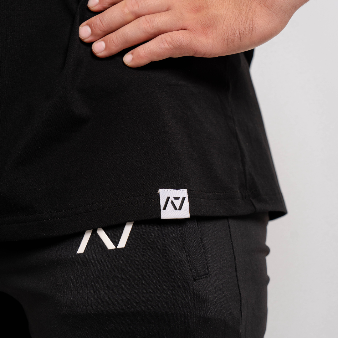 Close-up of the woven A7 hem tag at the bottom edge of the Domino shirt.