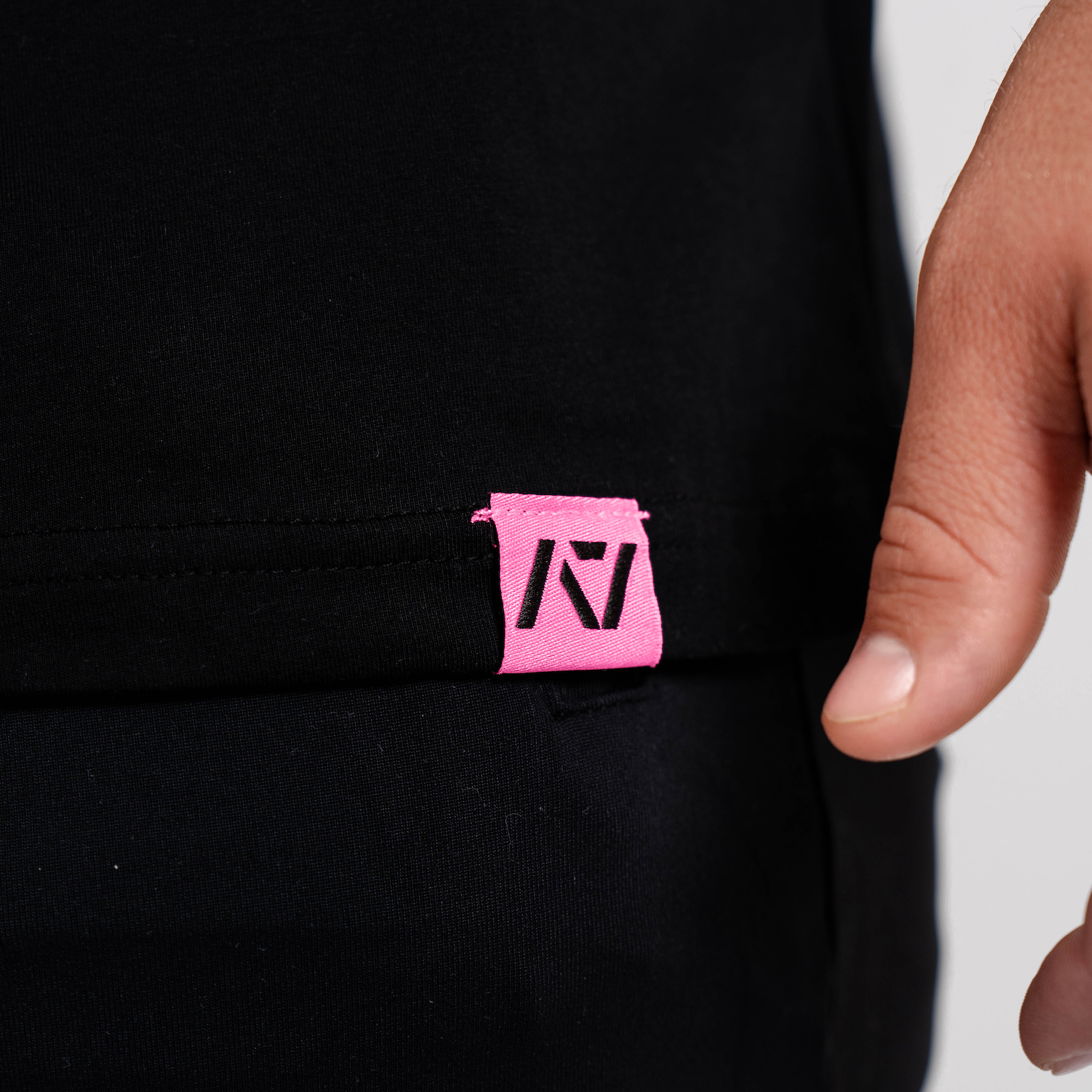 Close-up of woven A7 hem tag along the bottom hem of the Flamingo shirt.