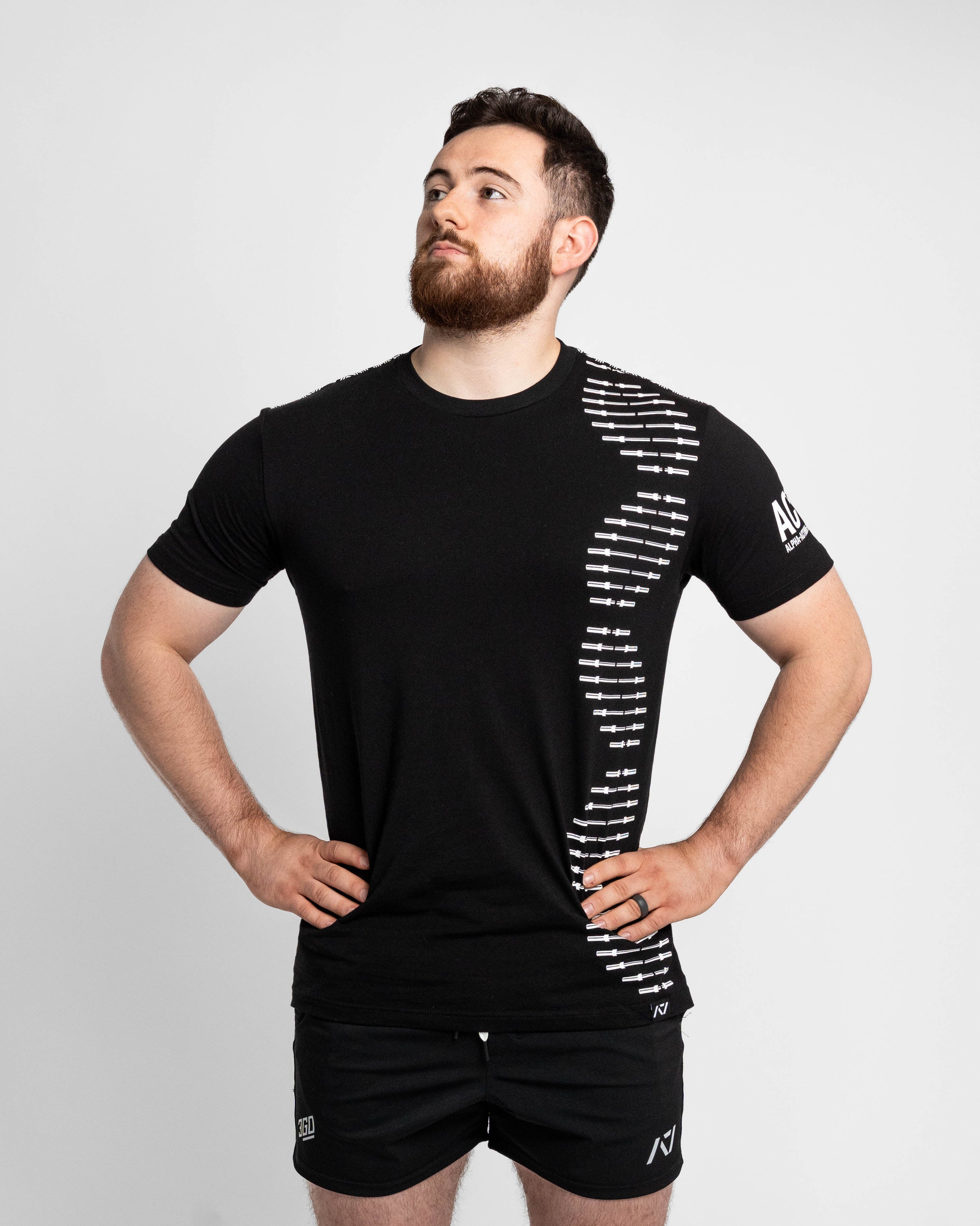 Man wearing a black athletic outfit with white graphics on a light gray background