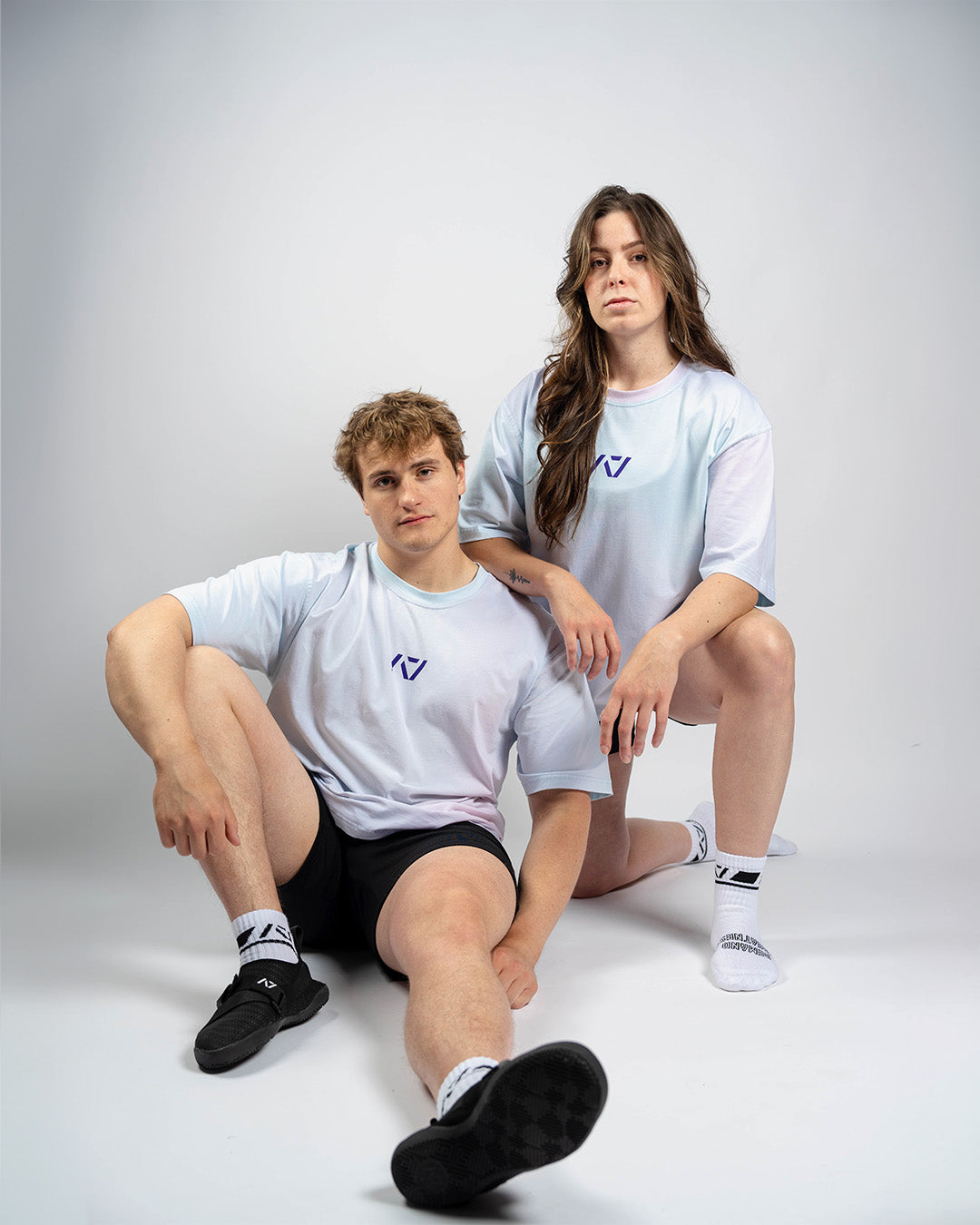 Male and female models wearing the A7 Affirmation Over-Fit Shirt – Pastel, demonstrating unisex oversized fit across body types.