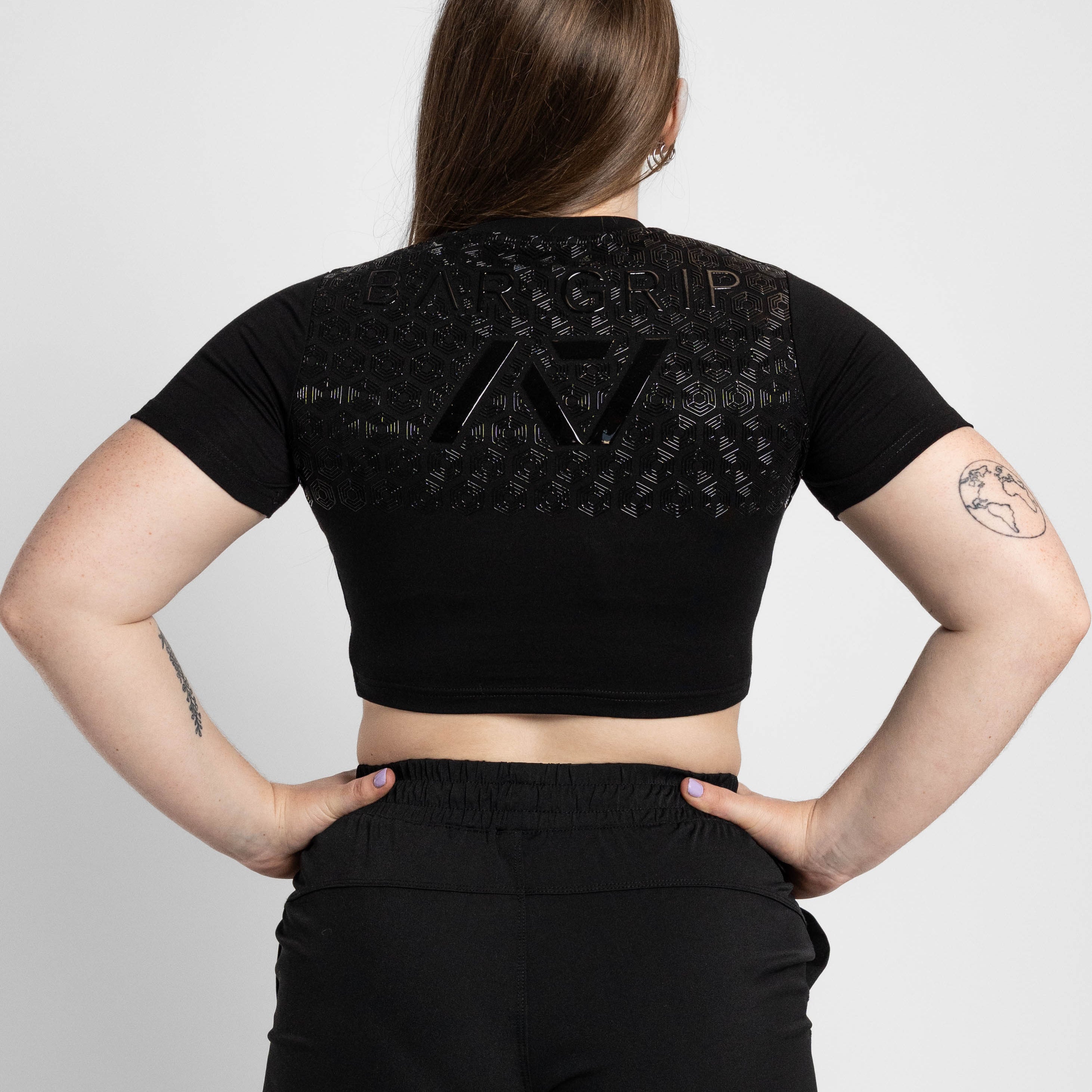 Person wearing a black crop top with bar grip