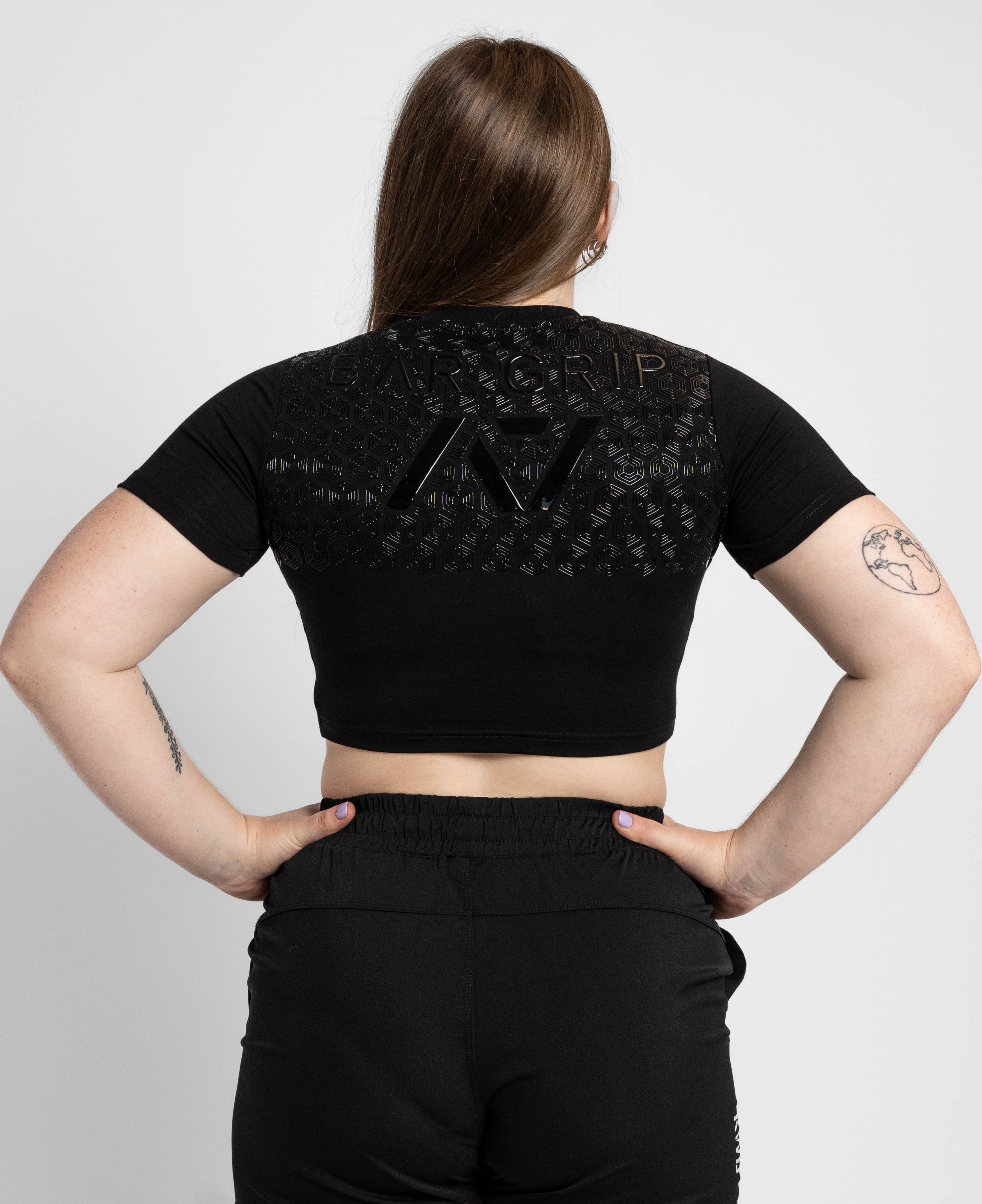Person wearing a black crop top with bar grip