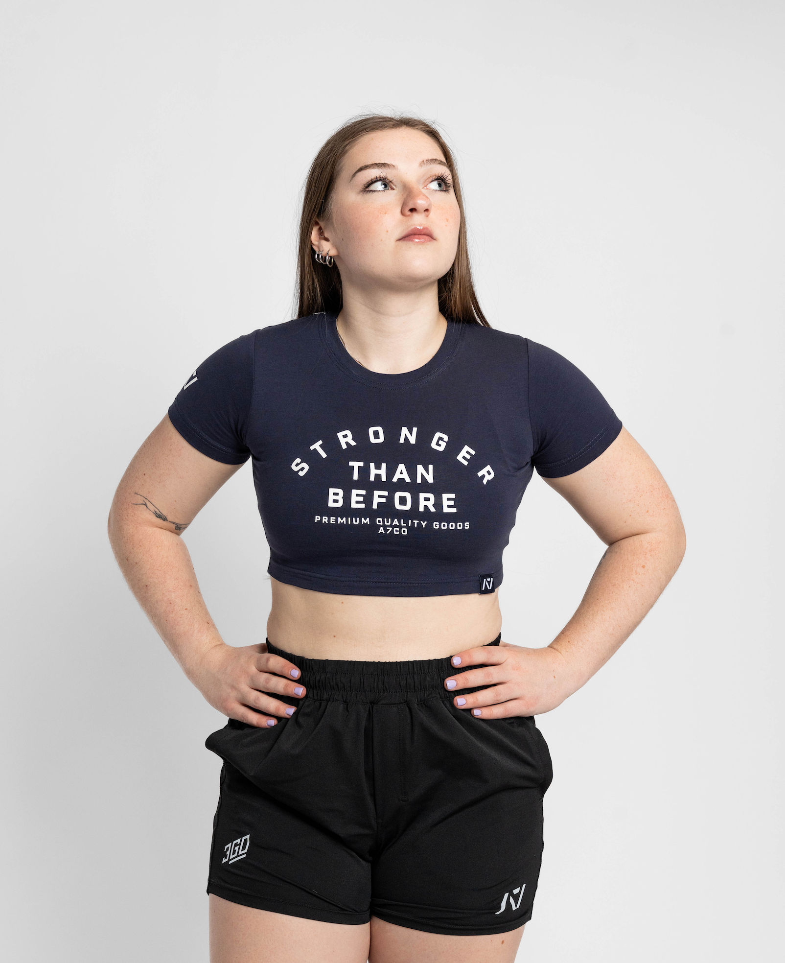 Person wearing a black 'Stronger Than Before' t-shirt and black shorts on a white background