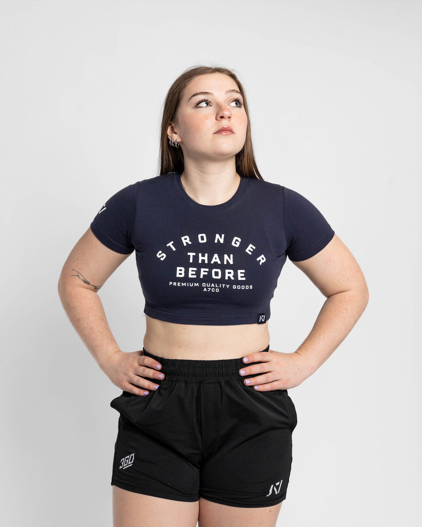 Person wearing a black 'Stronger Than Before' t-shirt and black shorts on a white background