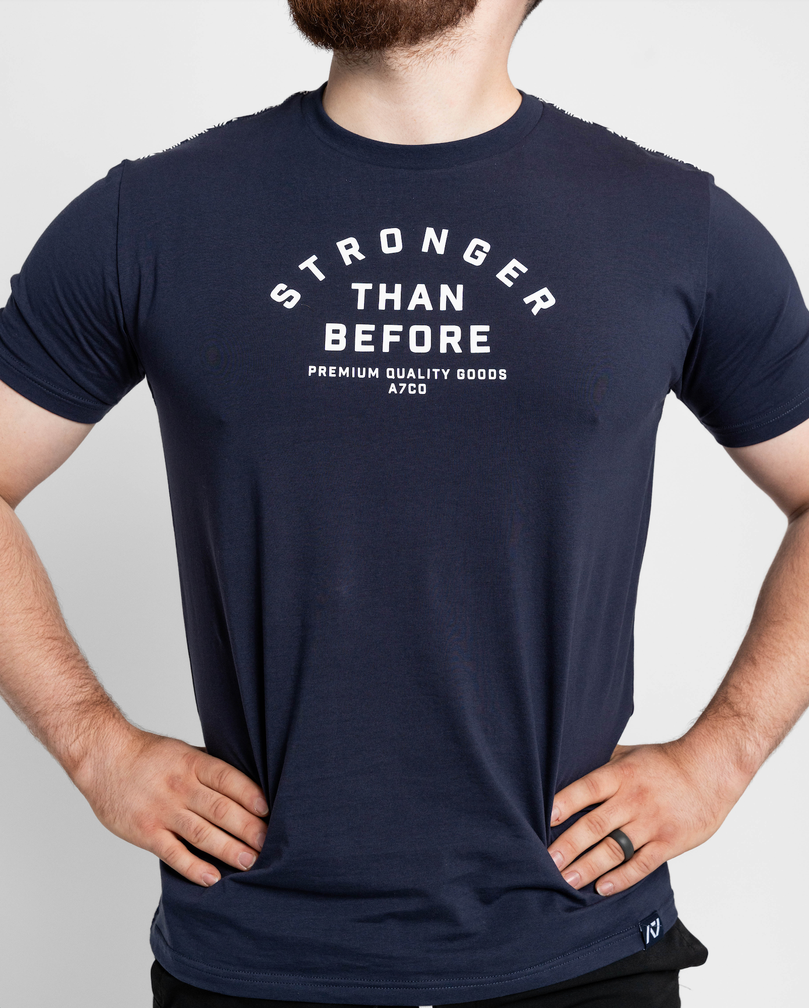 Person wearing a navy blue t-shirt with 'Stronger Than Before' text on a plain background