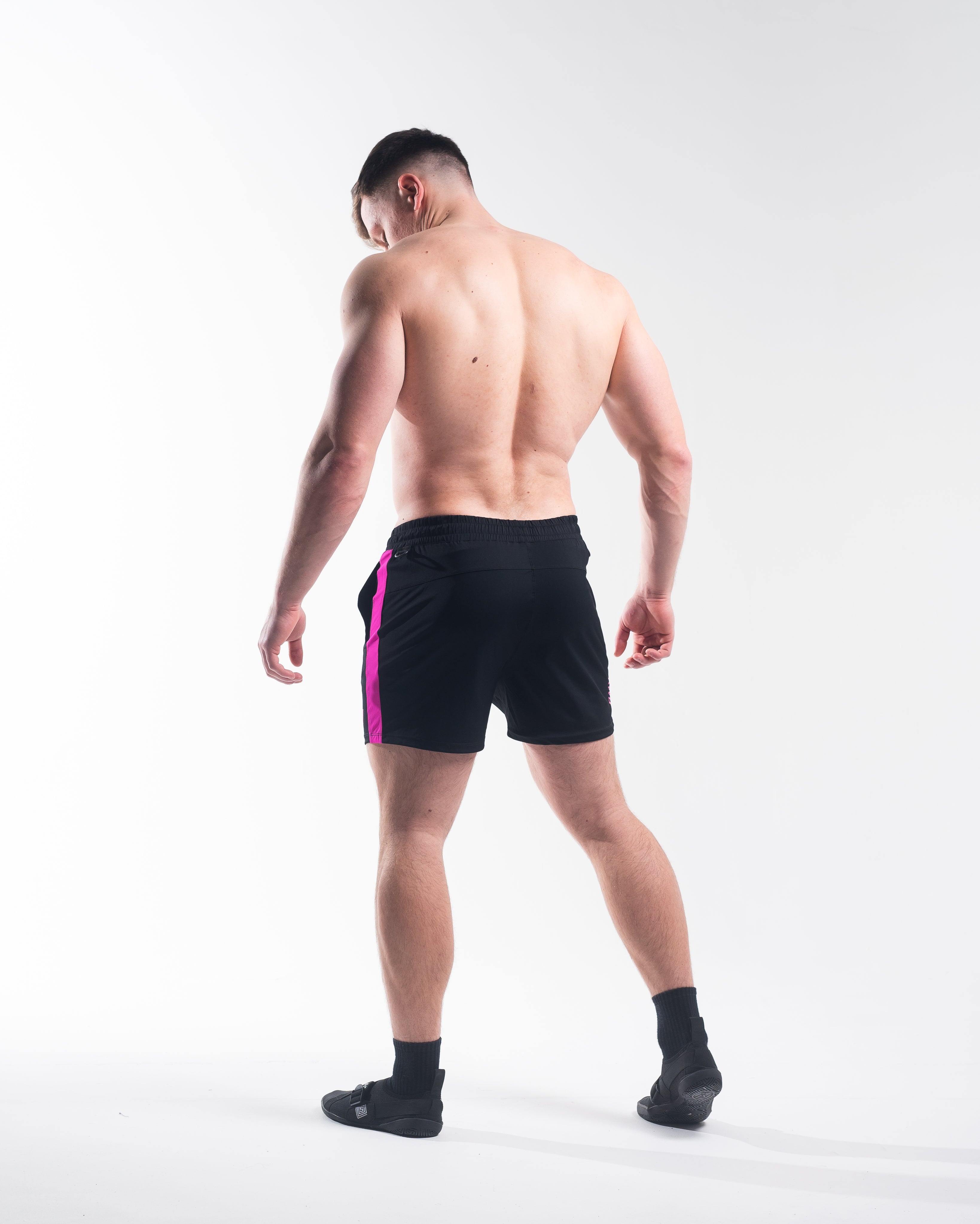 Full body image of athlete wearing A7 360Go KWD Shorts in Flamingo, showing fit, mobility, and bold colorway.