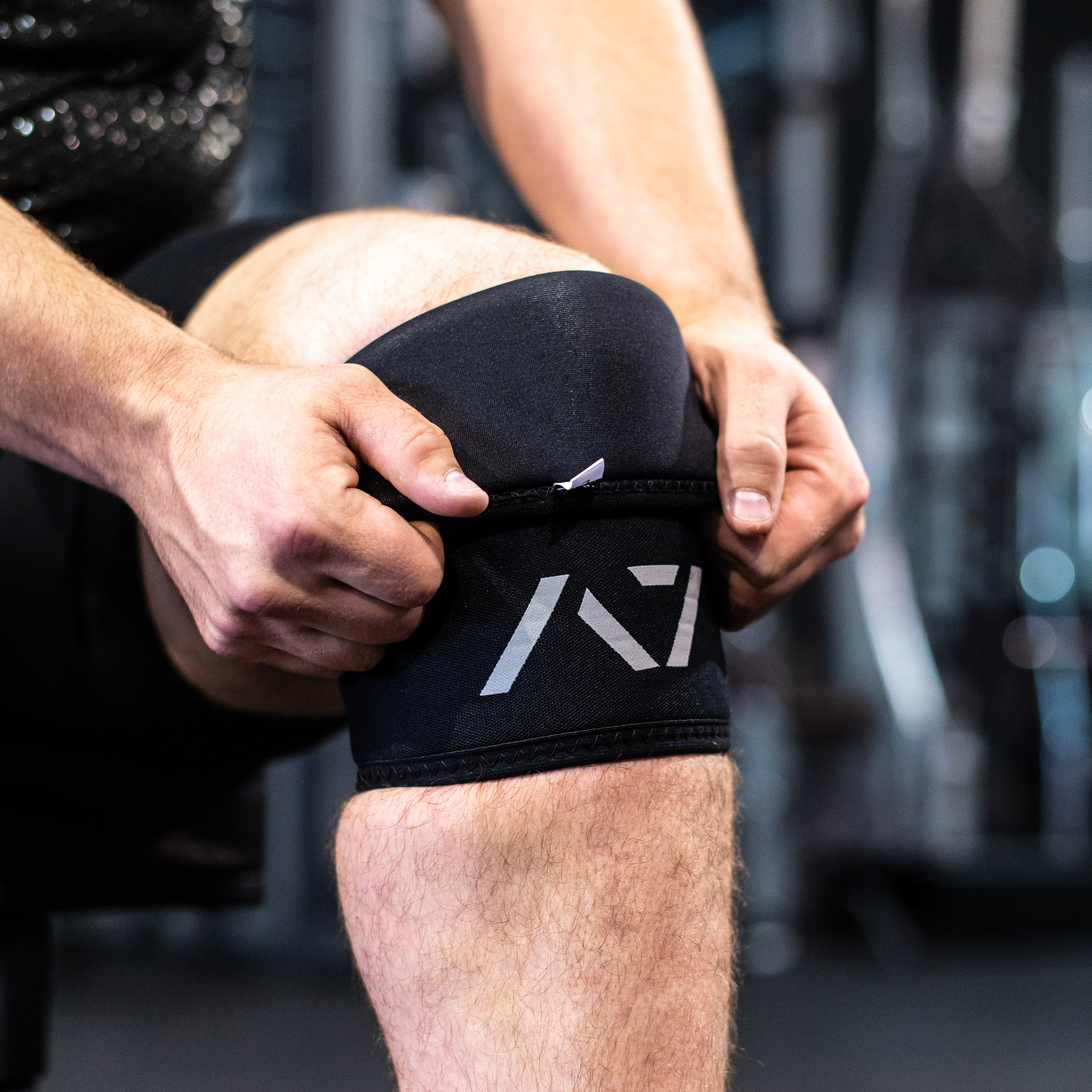 Detailed view of the reflective A7 logo on the black knee sleeves, emphasizing branding and design.