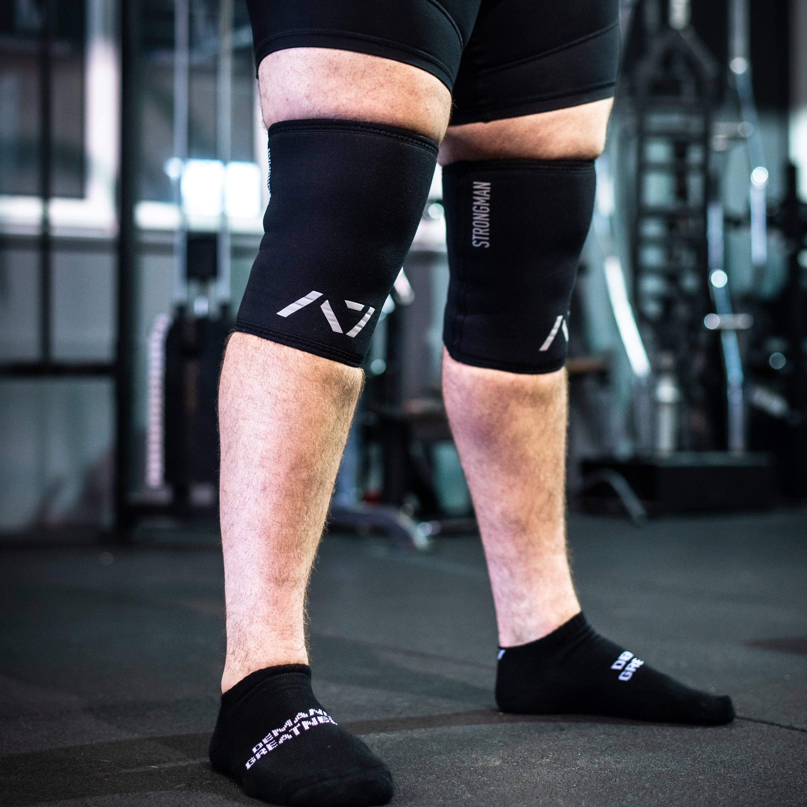 Both Sleeves of A7 Strongman Knee Sleeves – 9mm – Black/Reflective, displaying double-stitched seams and 9mm neoprene thickness.