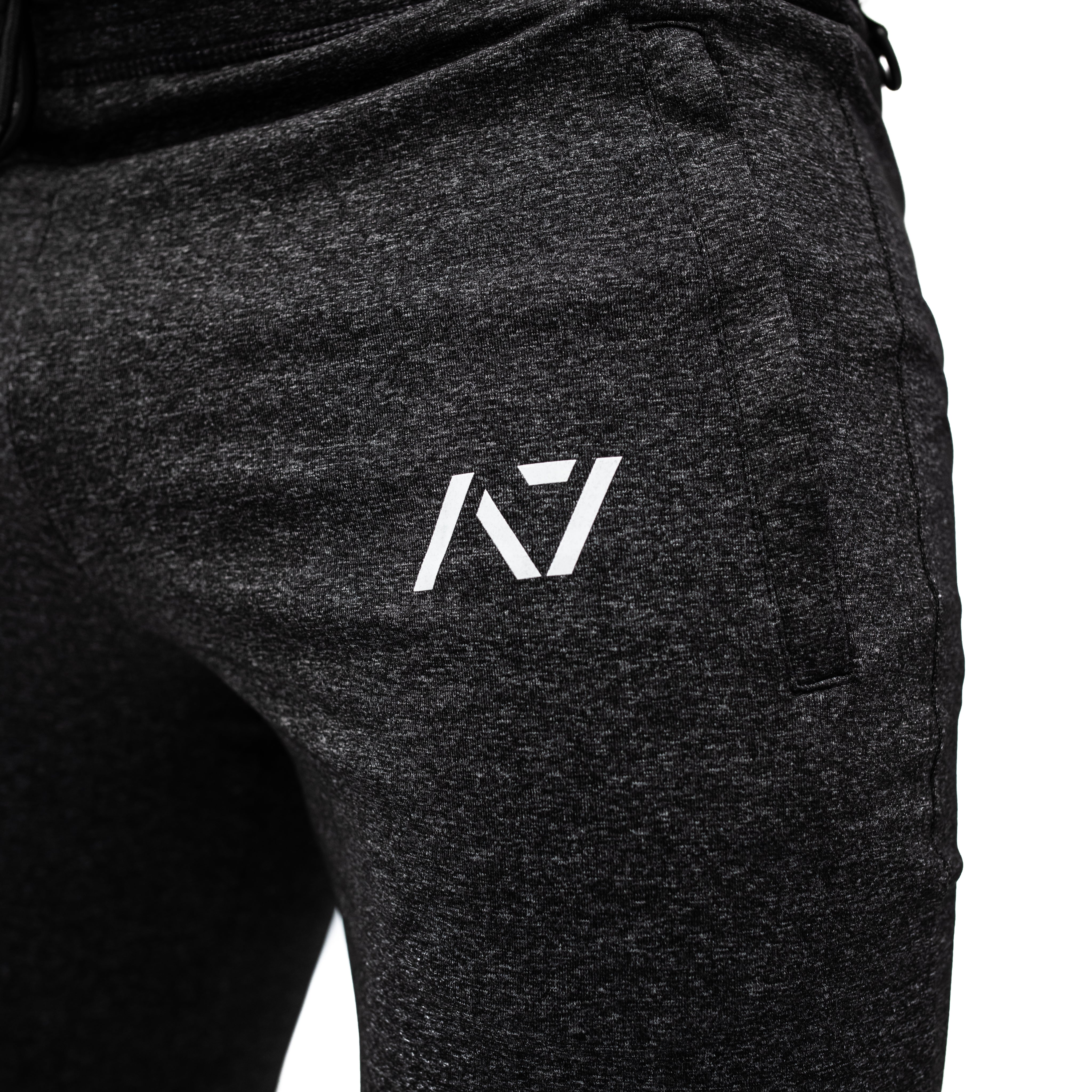 Close-up of silicone A7 logo printed on the thigh of Charcoal Defy Joggers.