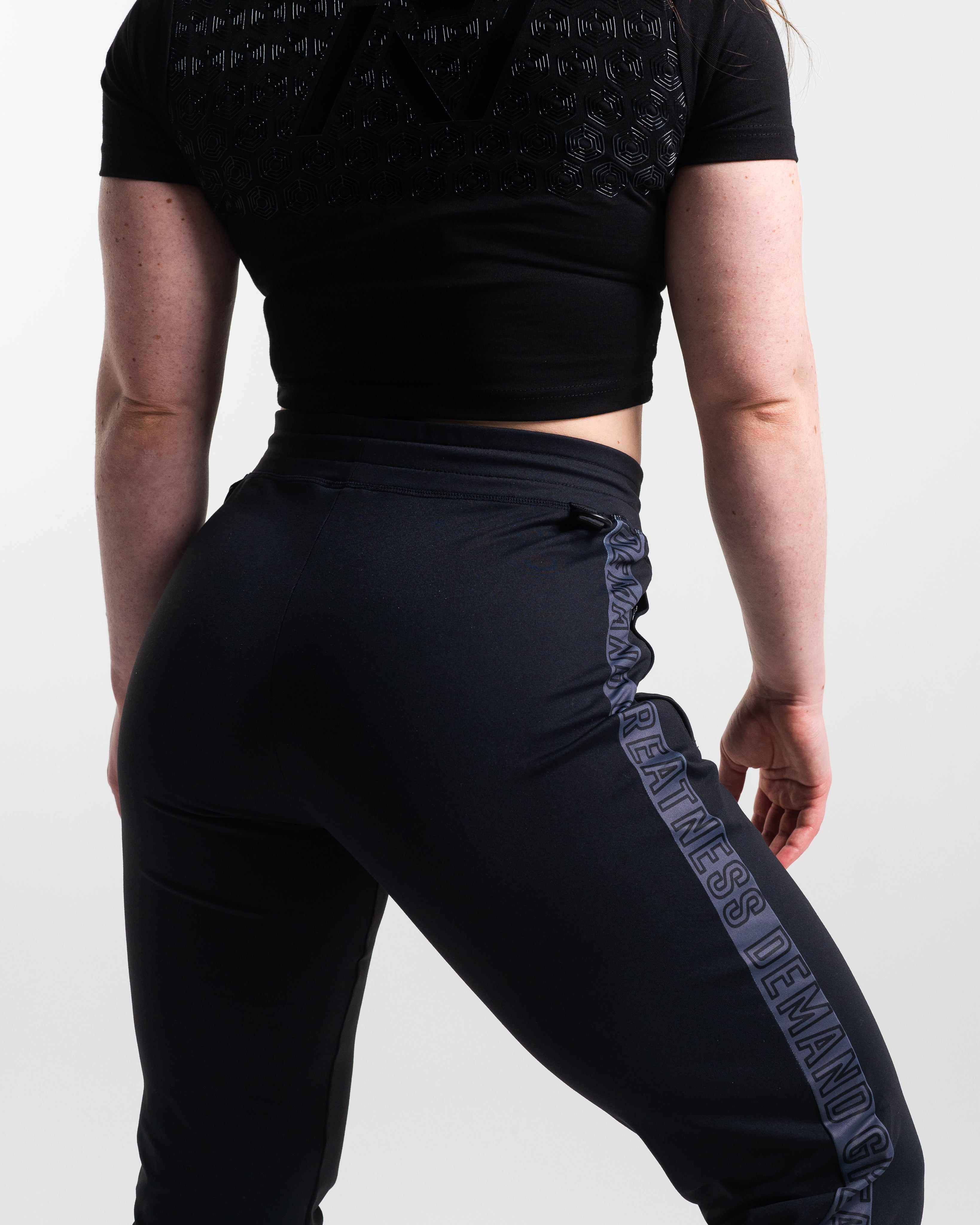 Female wearing shadow stone defy joggers with a visible brand logo on a plain background