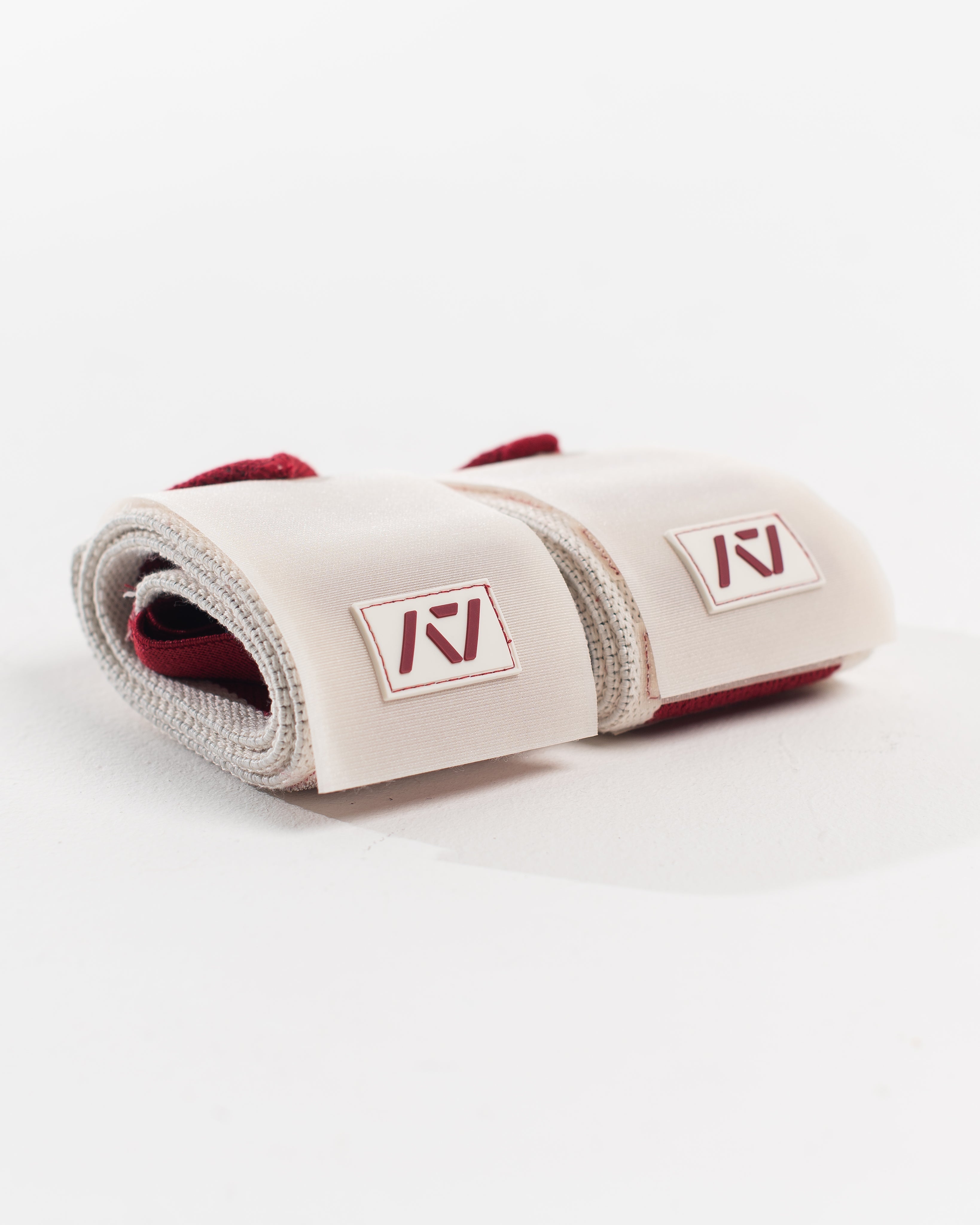 Close up of A7 logo patch on both wrist wraps in ivory with red accents
