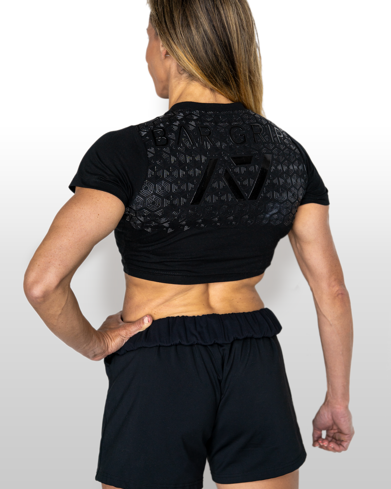 Person wearing a black athletic outfit with A7 BAR GRIP on a white background
