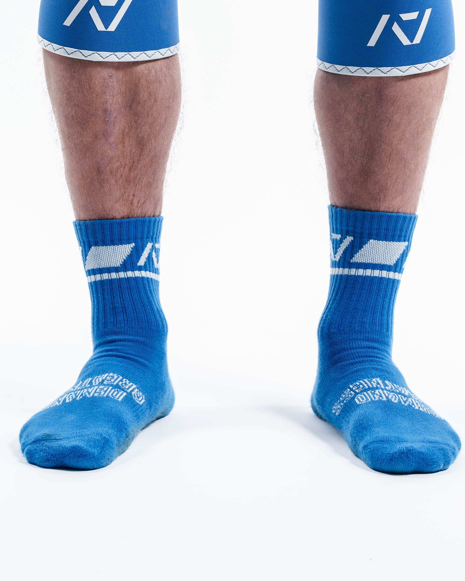 Front view of A7 Crew Socks in Cyanite featuring bold cyan base with pink A7 logo and ribbed cuff.